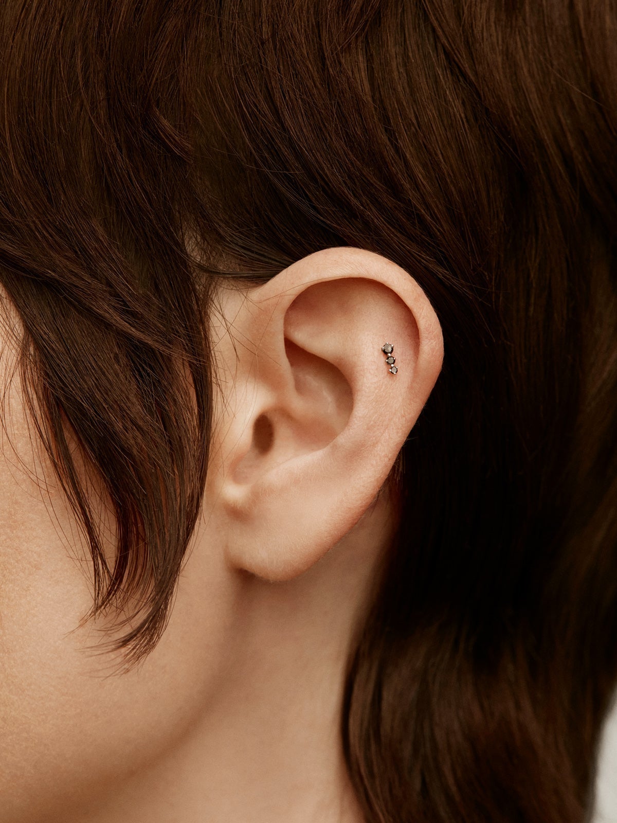 Piercing de oro blanco de 18k con diamantes negros