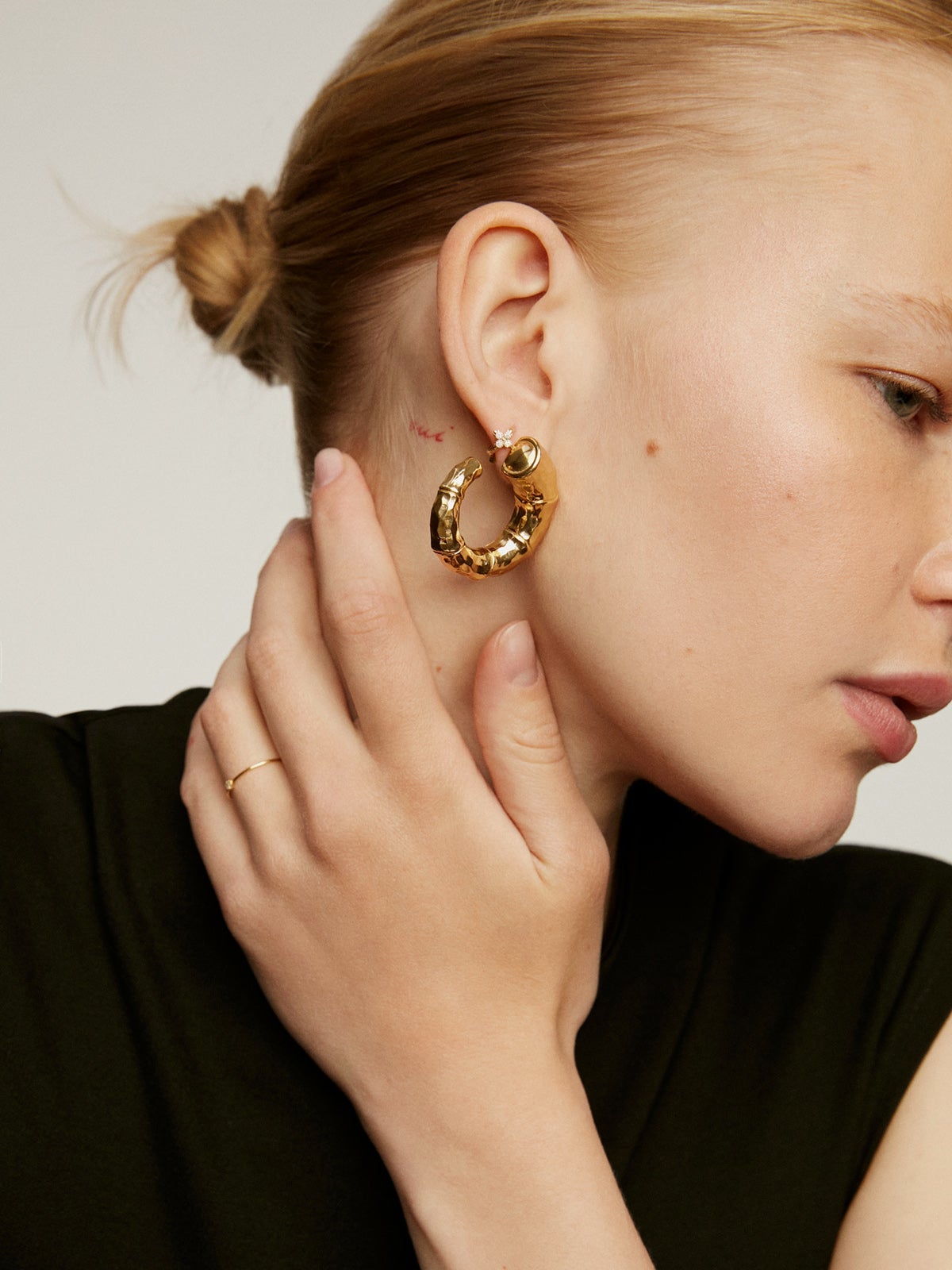 Pendiente individual de aro pequeño de oro amarillo de 18K con cruz de diamantes