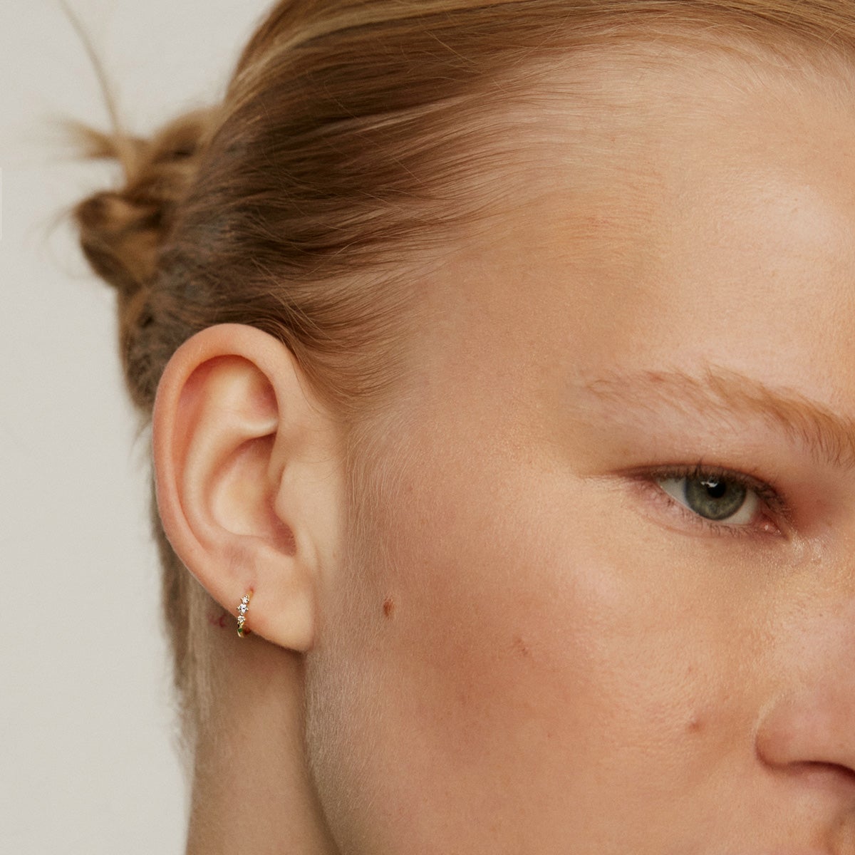 Pendiente individual pequeño de aro de oro amarillo de 18K con triple diamante