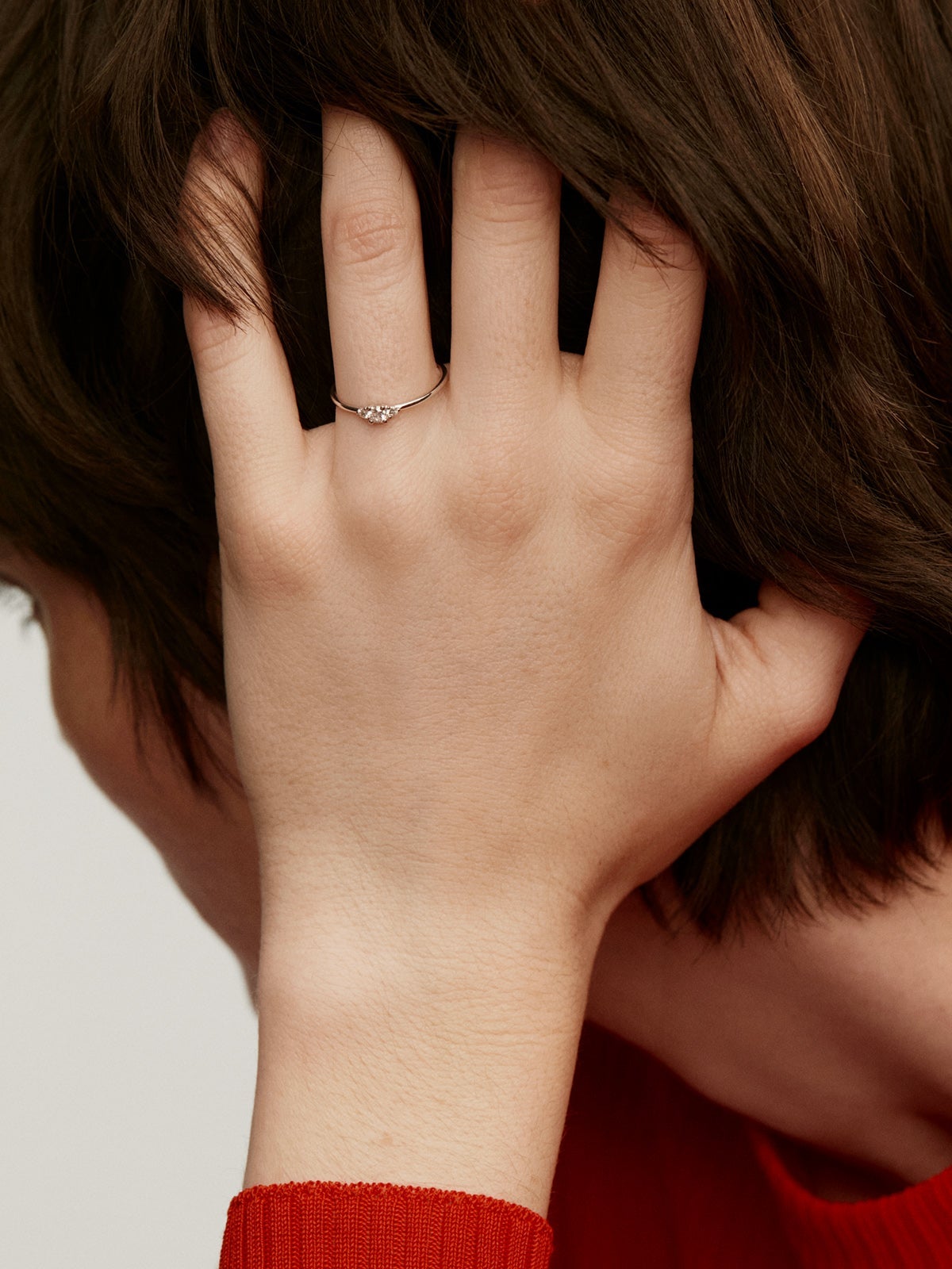 Anillo tresillo de oro blanco de 18K con diamante central de 0,10cts y diamantes