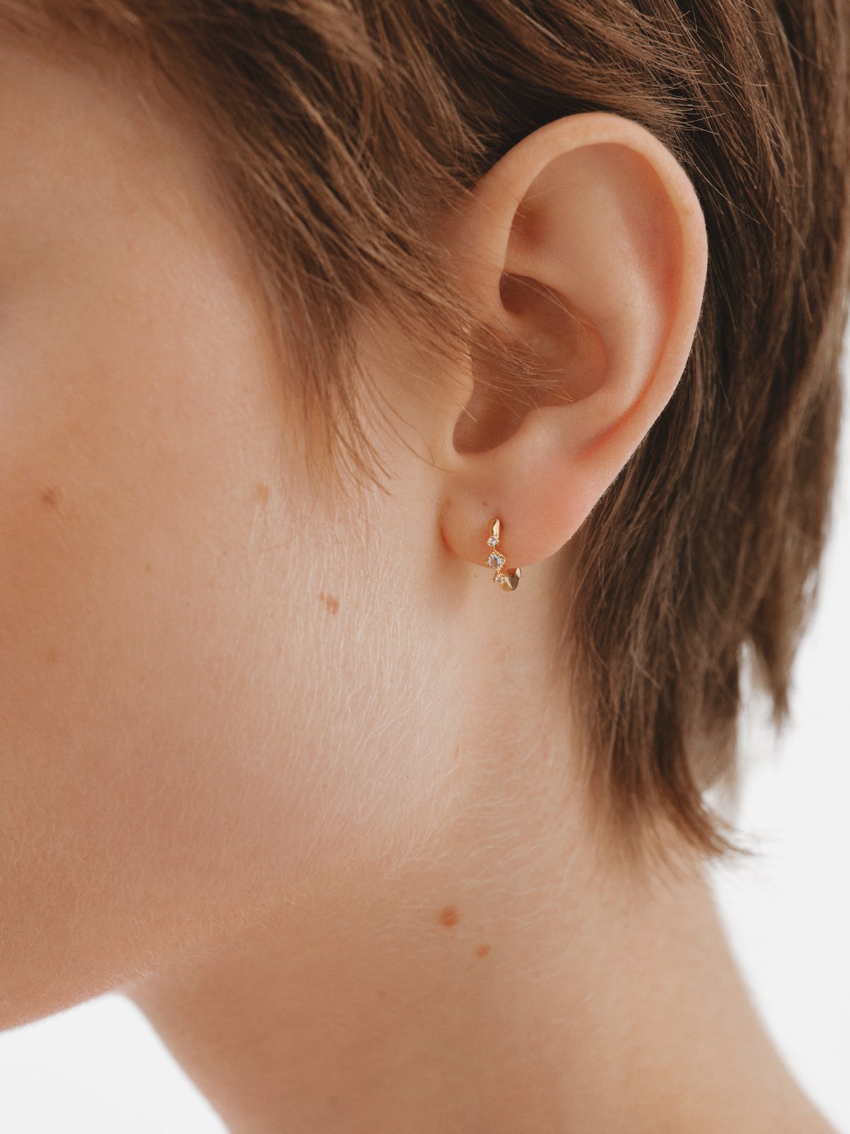 Pendiente individual de aro de plata 925 bañada en oro amarillo de 18K con topacios azules y blancos