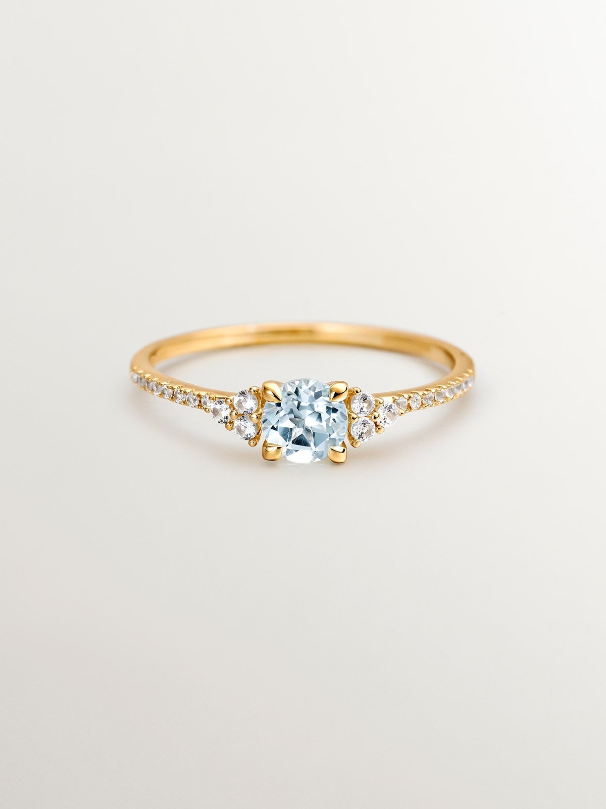 Anillo de plata 925 bañada en oro amarillo de 18K con topacio azul sky y zafiros blancos