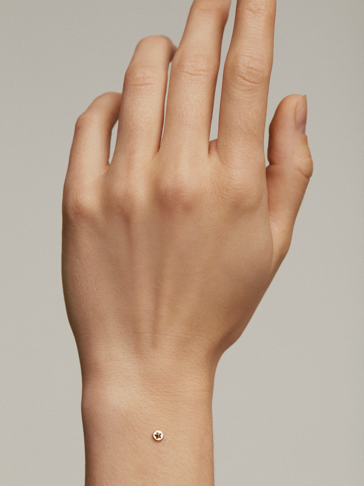 Microdermal de oro amarillo de 18K y titanio con estrella