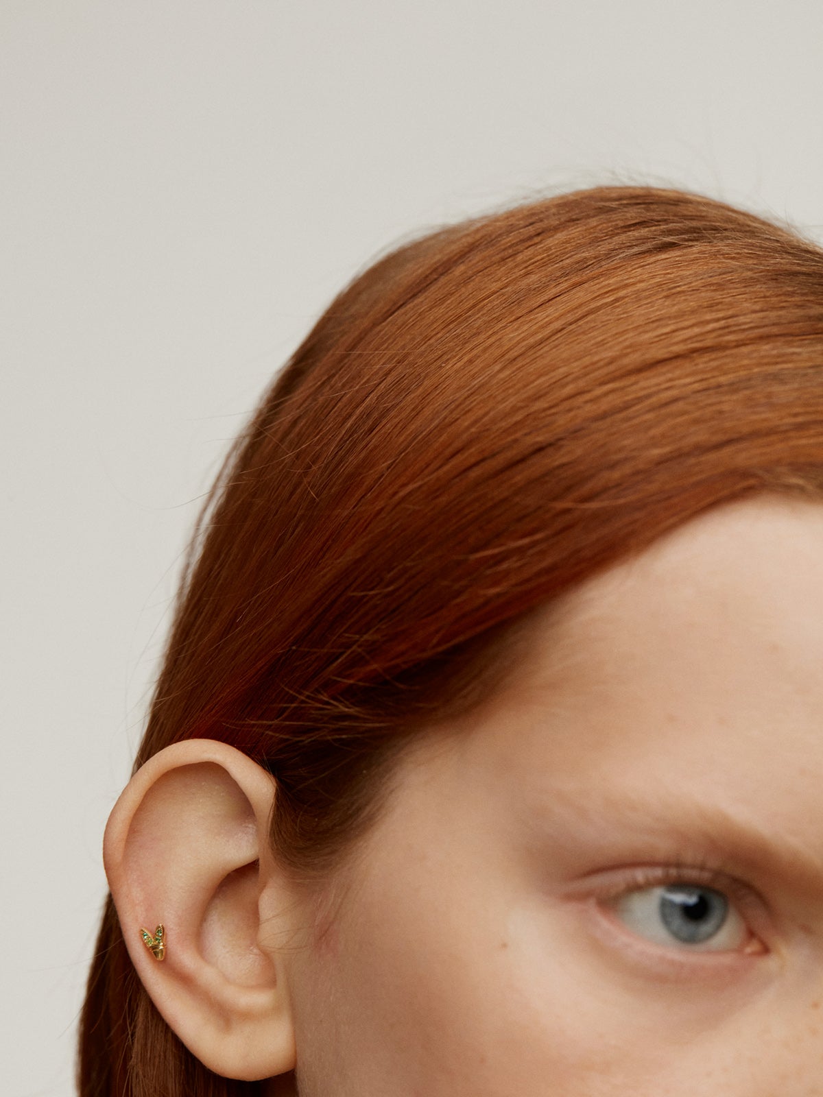 Piercing de oro amarillo de 18K con esmeraldas y forma de alas