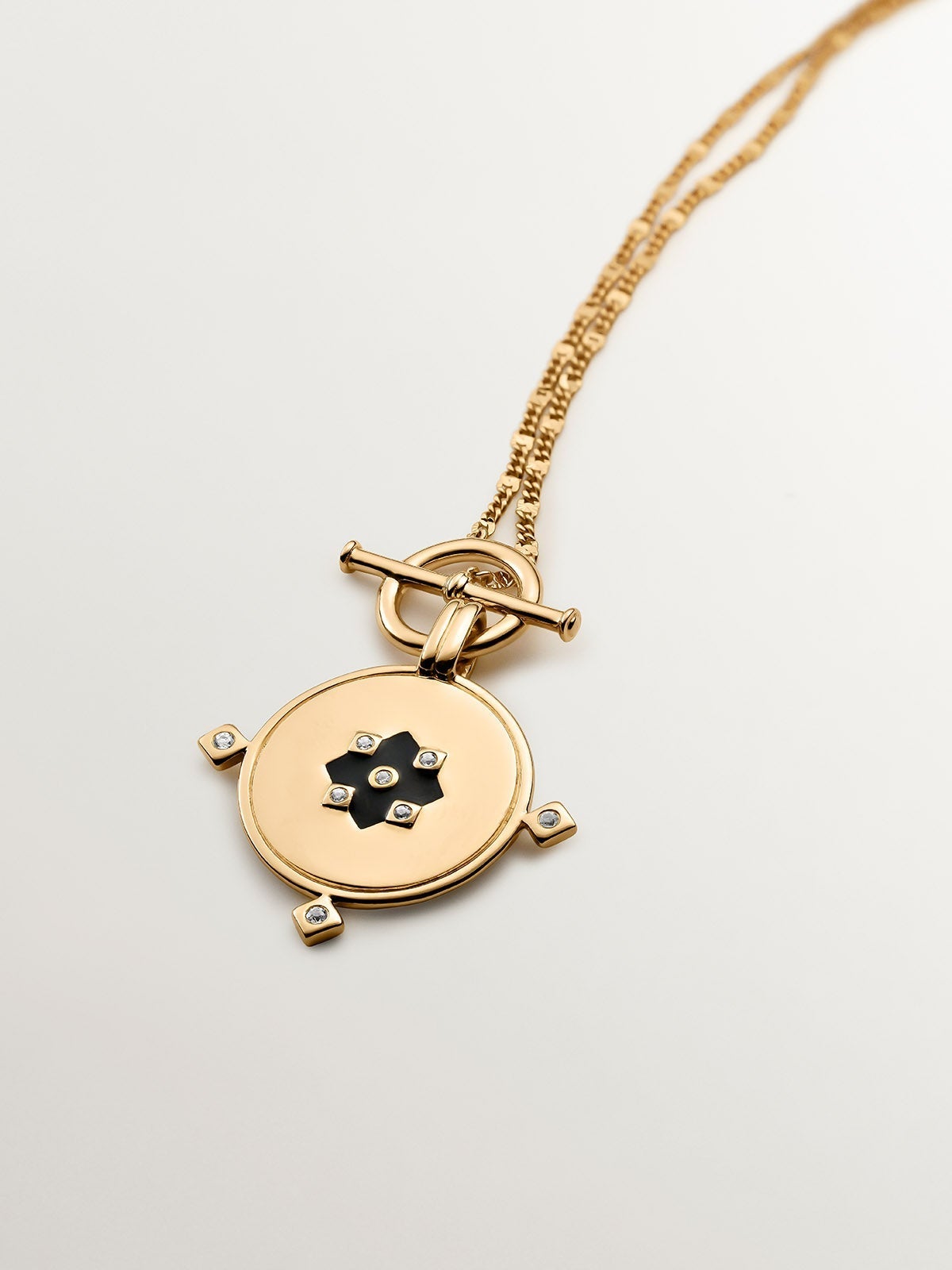 Colgante de plata 925 bañada en oro amarillo de 18K con medalla, topacios blancos y esmalte negro