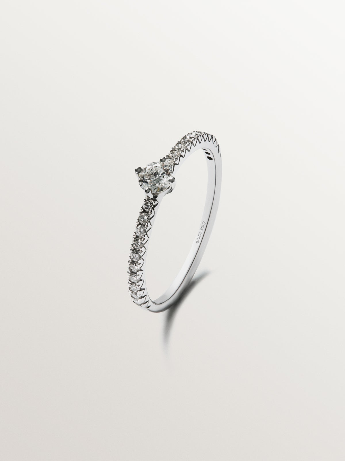 Anillo de oro blanco de 18K con brazo de diamantes y diamante central 0,23 cts