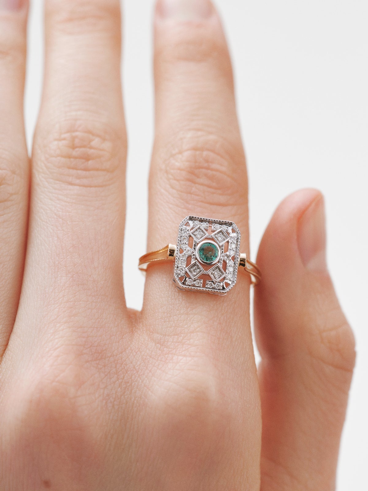 Anillo de oro blanco y oro amarillo de 18K con diamantes en talla brillante y esmeraldas en talla brillante