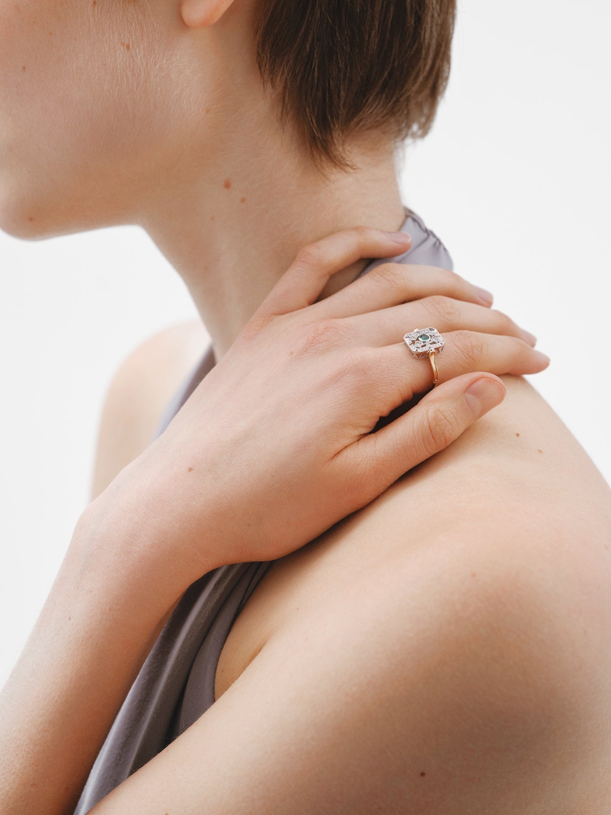 Anillo de oro blanco y oro amarillo de 18K con diamantes en talla brillante y esmeraldas en talla brillante