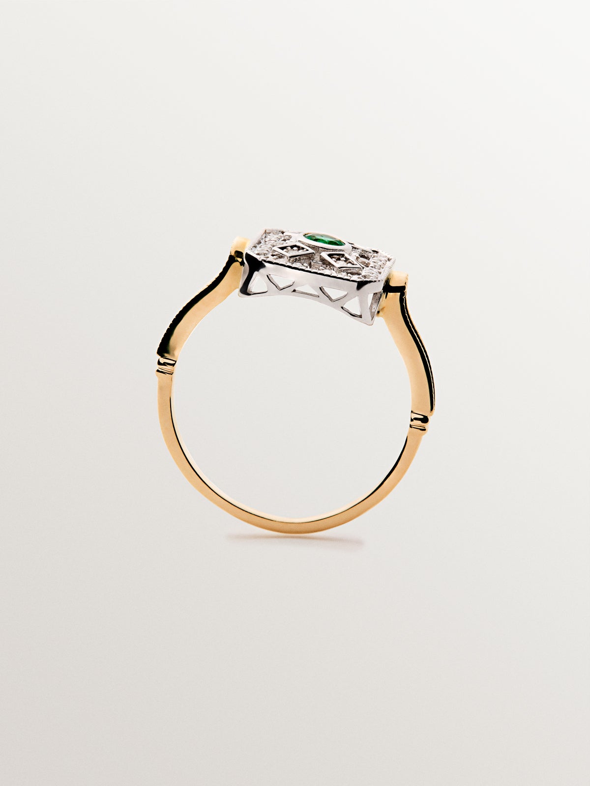 Anillo de oro blanco y oro amarillo de 18K con diamantes en talla brillante y esmeraldas en talla brillante