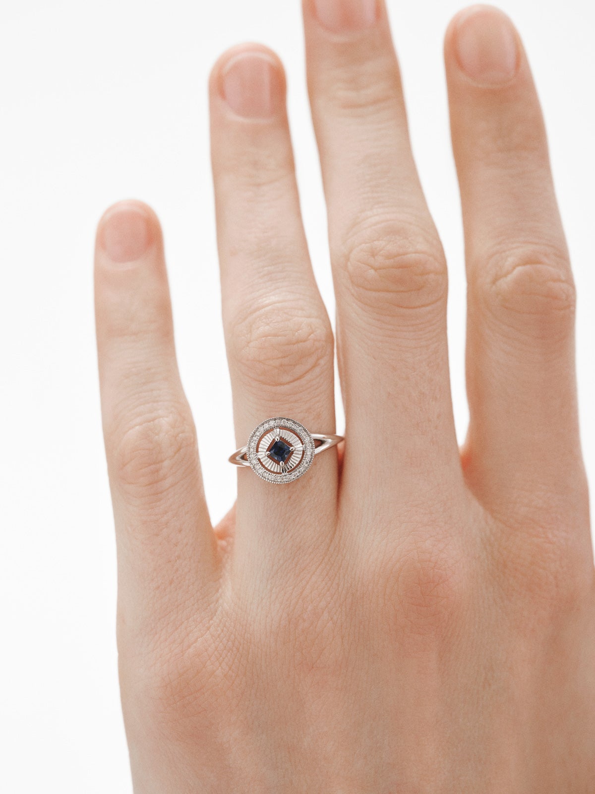 Anillo de oro blanco de 18K con diamantes en talla brillante y zafiro azul en talla princesa