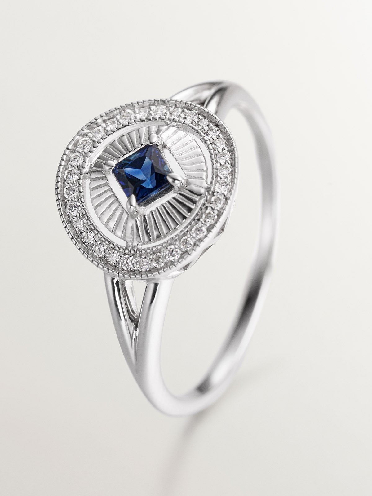 Anillo de oro blanco de 18K con diamantes en talla brillante y zafiro azul en talla princesa