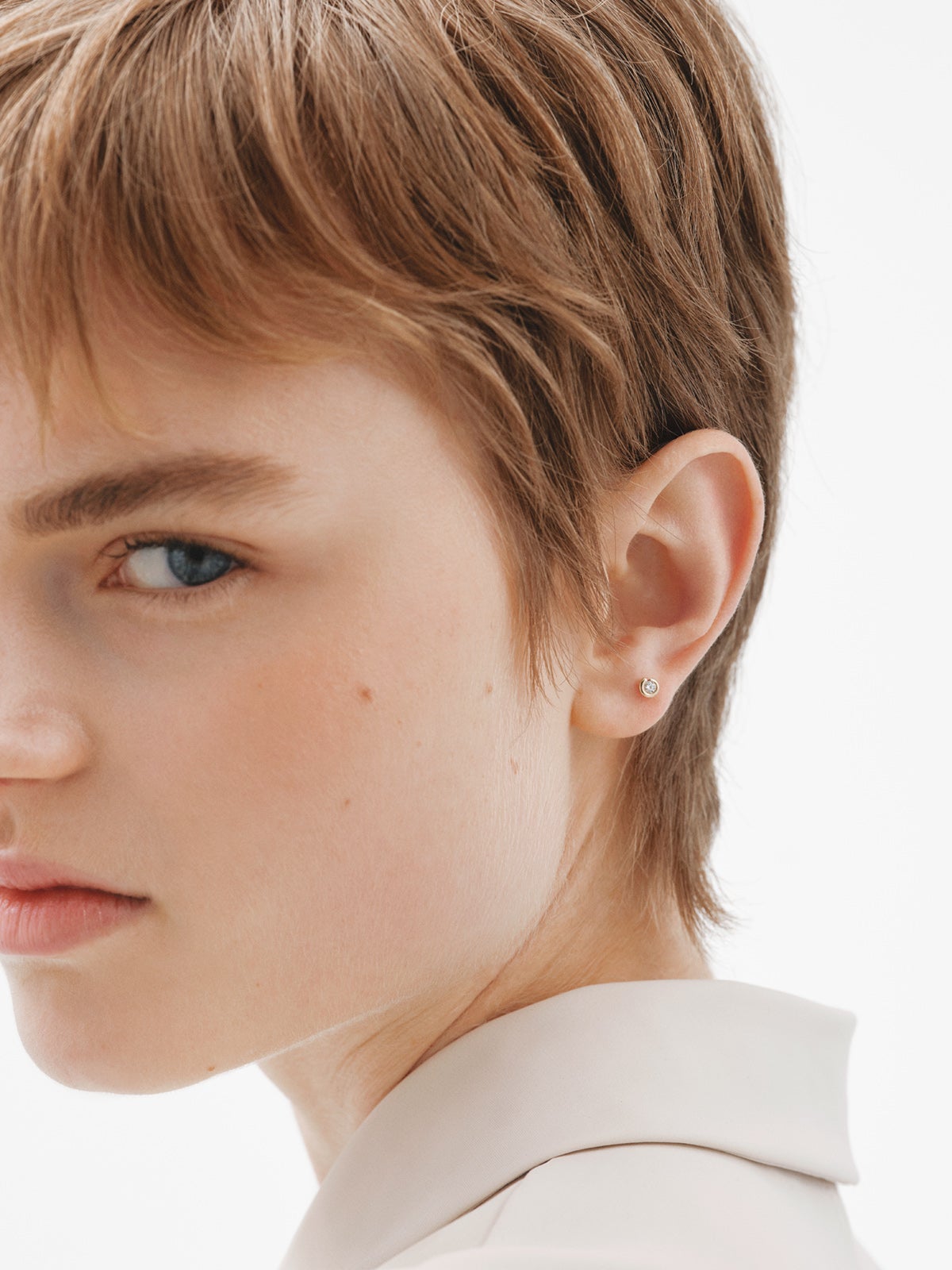 Piercing individual de oro amarillo de 18K con diamante central blanco en talla brillante.
