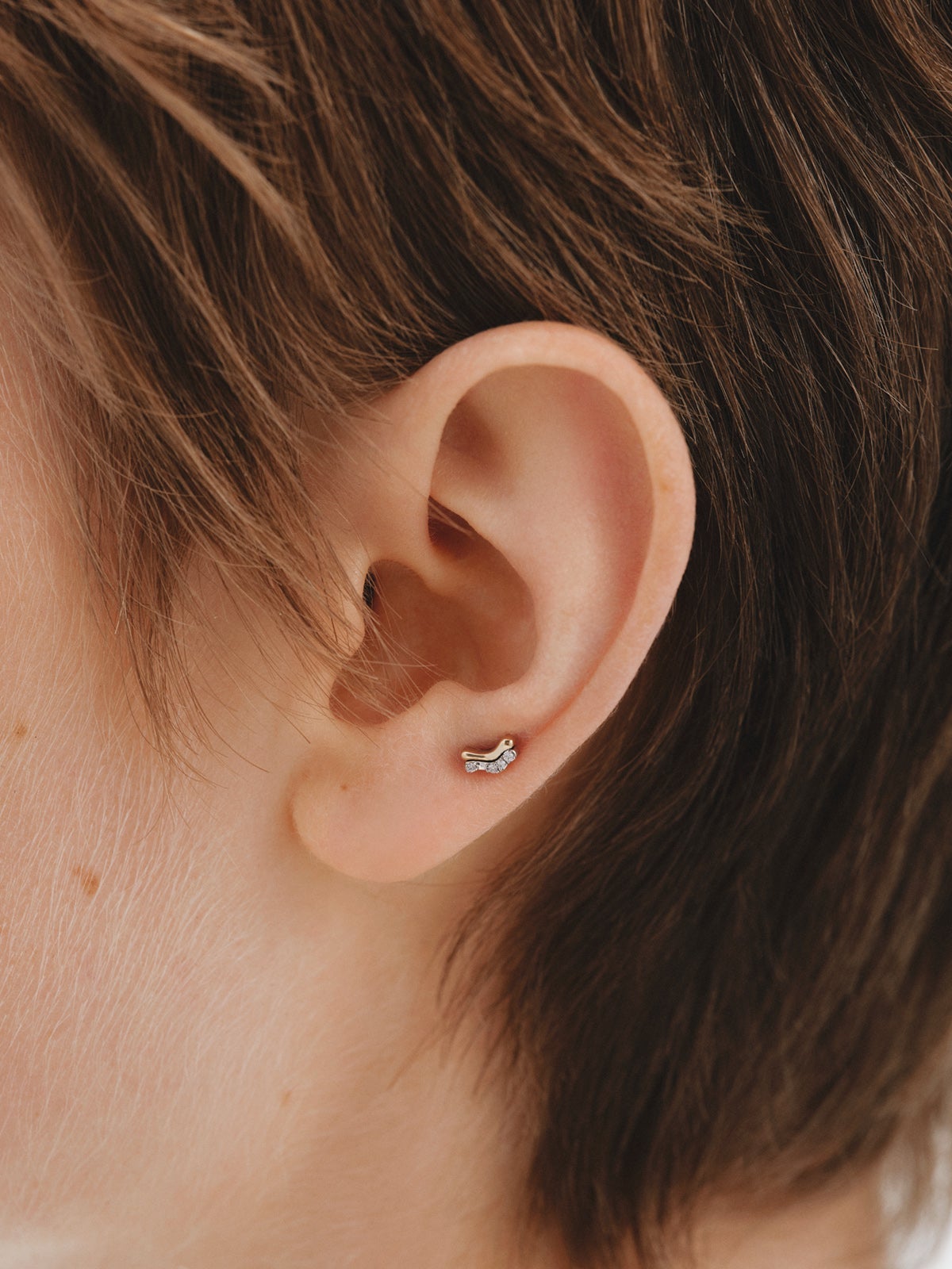 Piercing individual de oro amarillo y blanco de 18K con diamantes blancos en talla brillante.