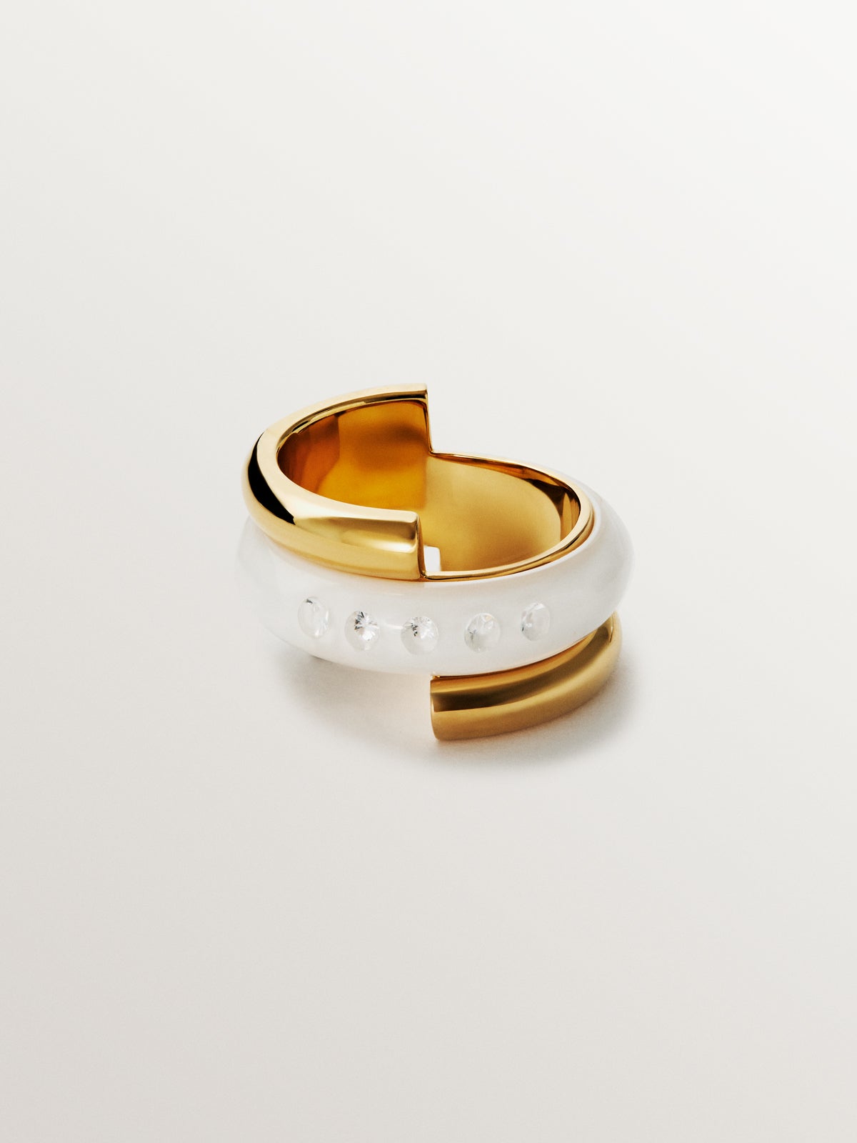 Anillo de plata 925 bañada en oro amarillo de 18K con esmalte blanco y circones suspendidos en resina