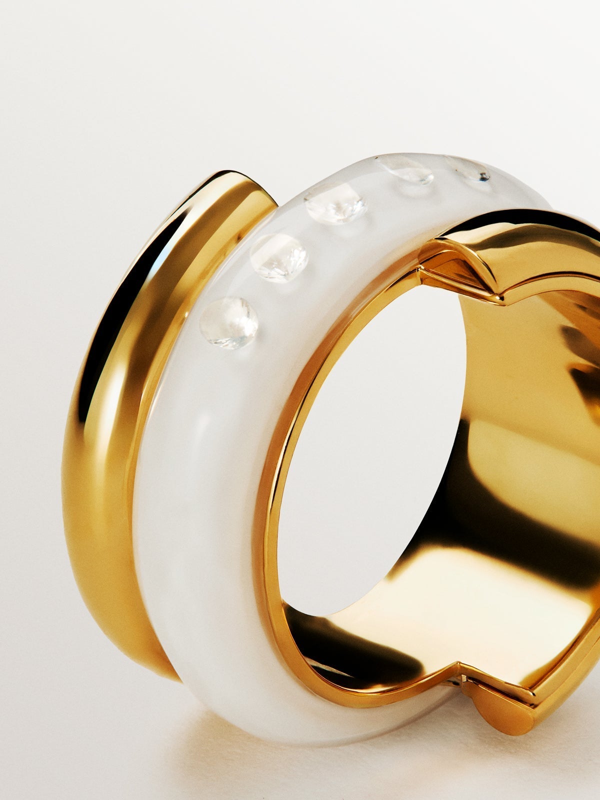 Anillo de plata 925 bañada en oro amarillo de 18K con esmalte blanco y circones suspendidos en resina