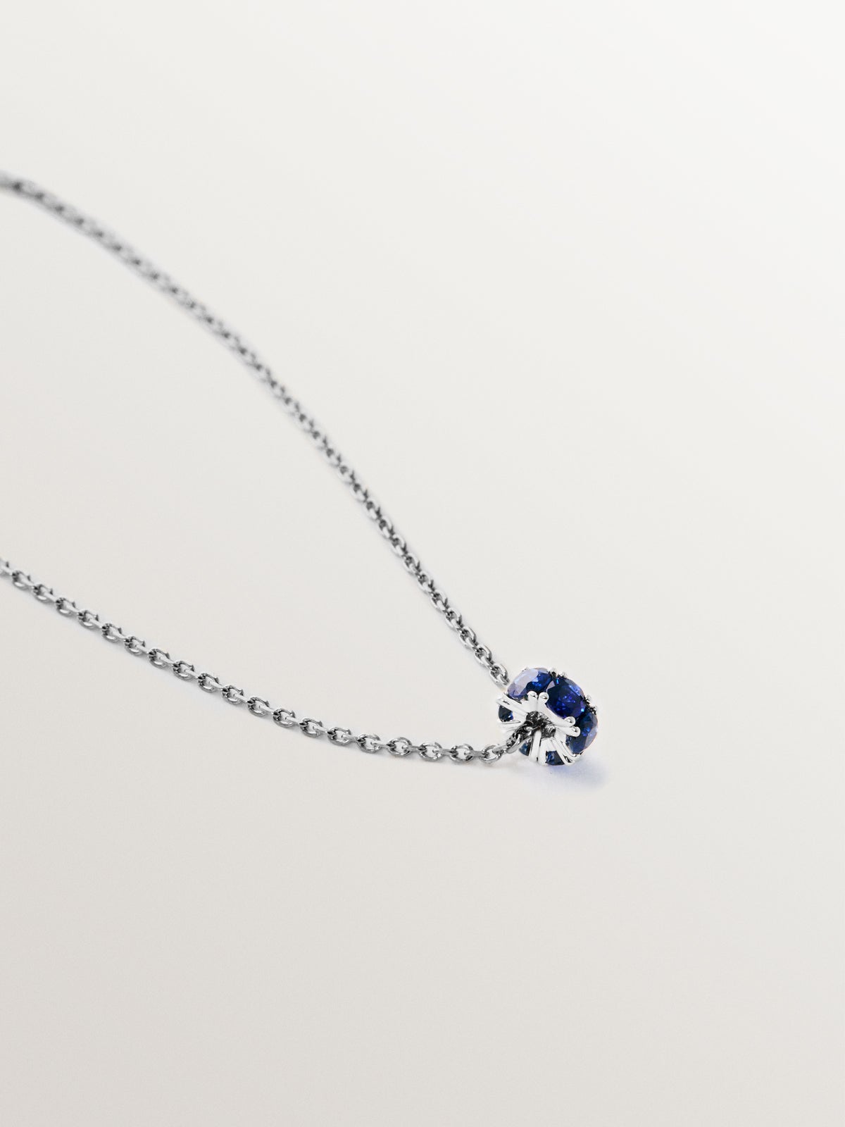 Colgante de oro blanco de 9K con zafiros azules y diamantes