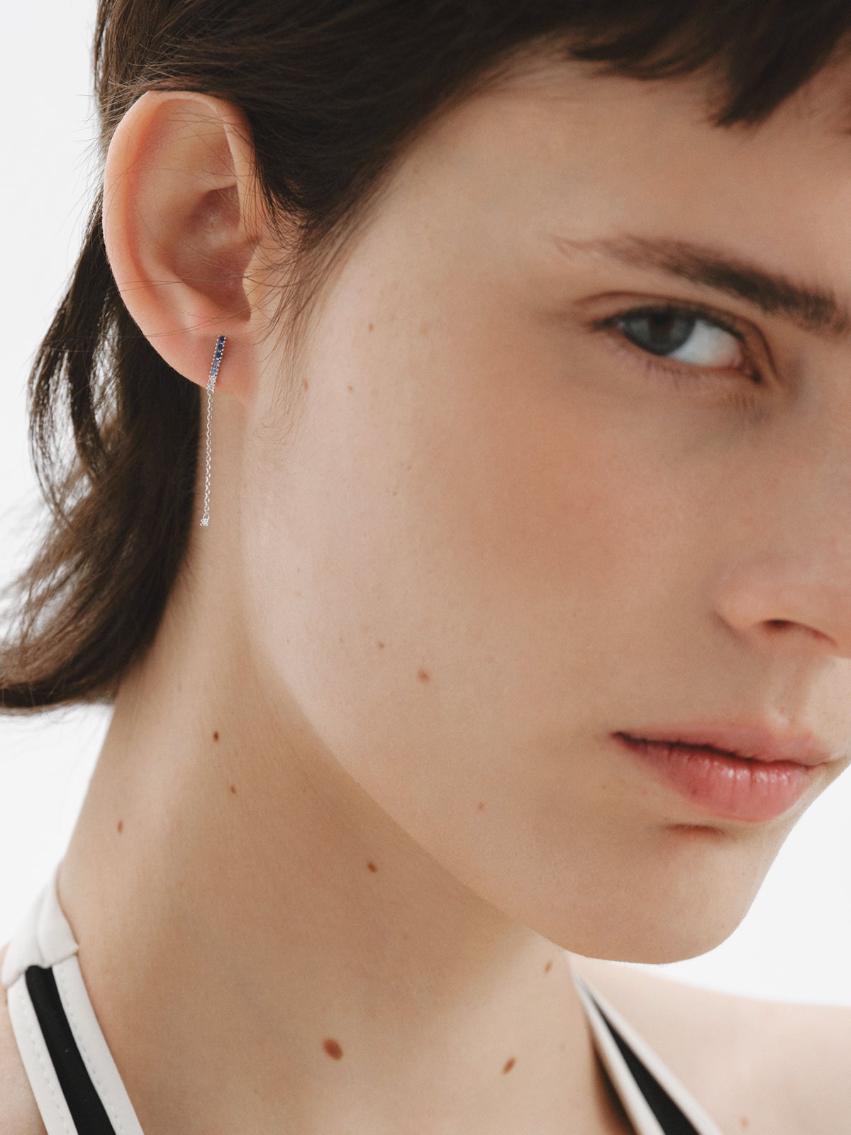 Pendiente largo individual de oro blanco de 9K con zafiros azules y diamantes