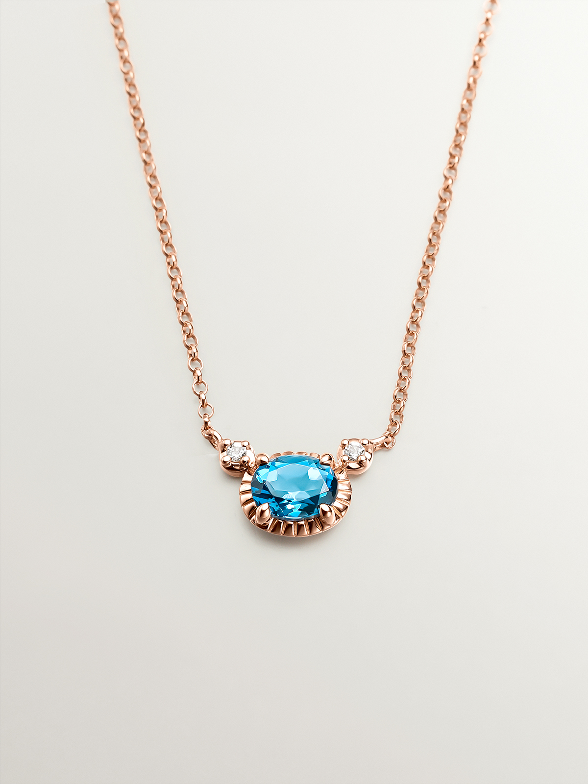 925 Silver pendant dipped in 18K rose gold with London blue and white topazes.
