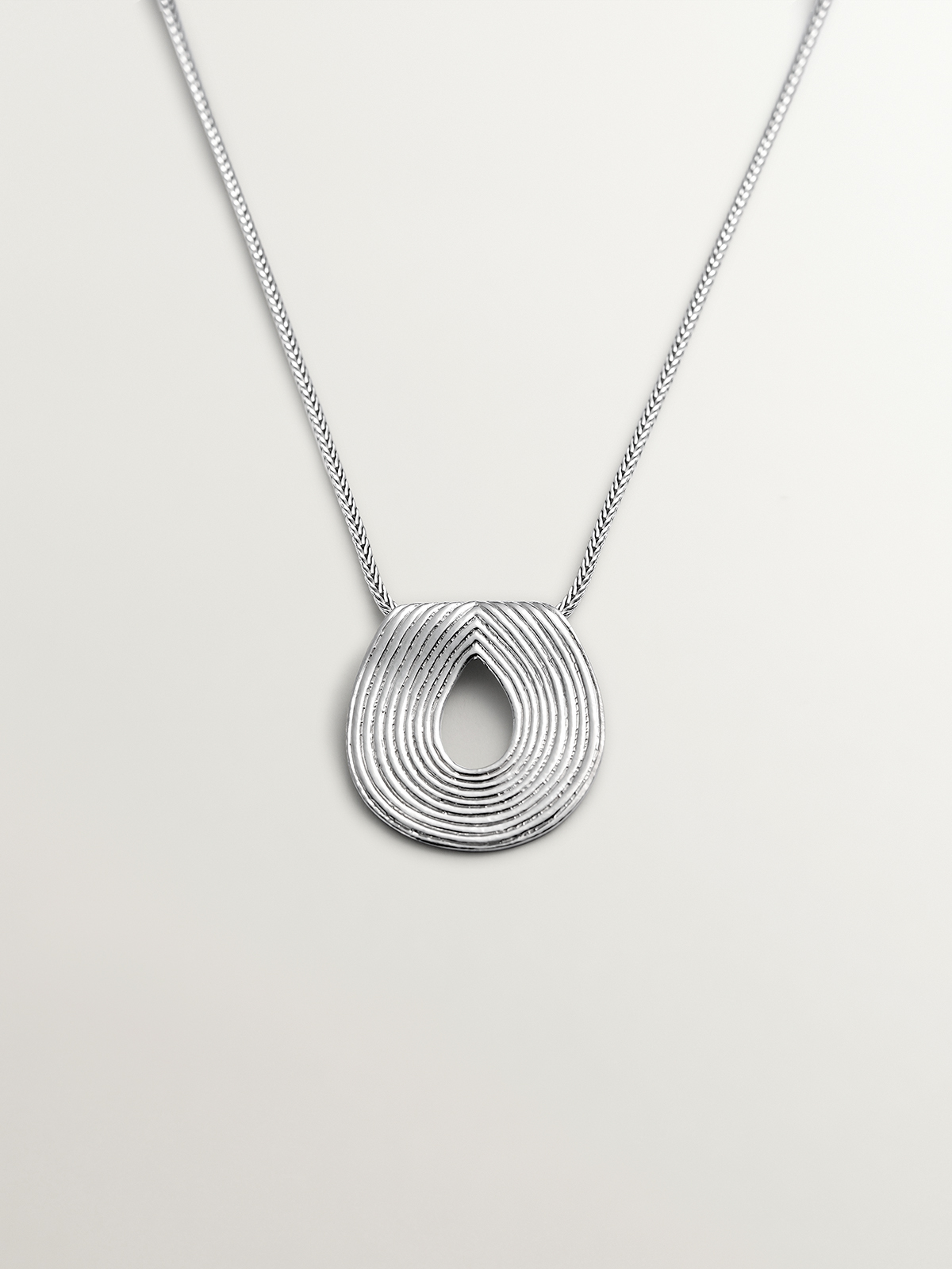 Oval-shaped 925 silver pendant with embossing.