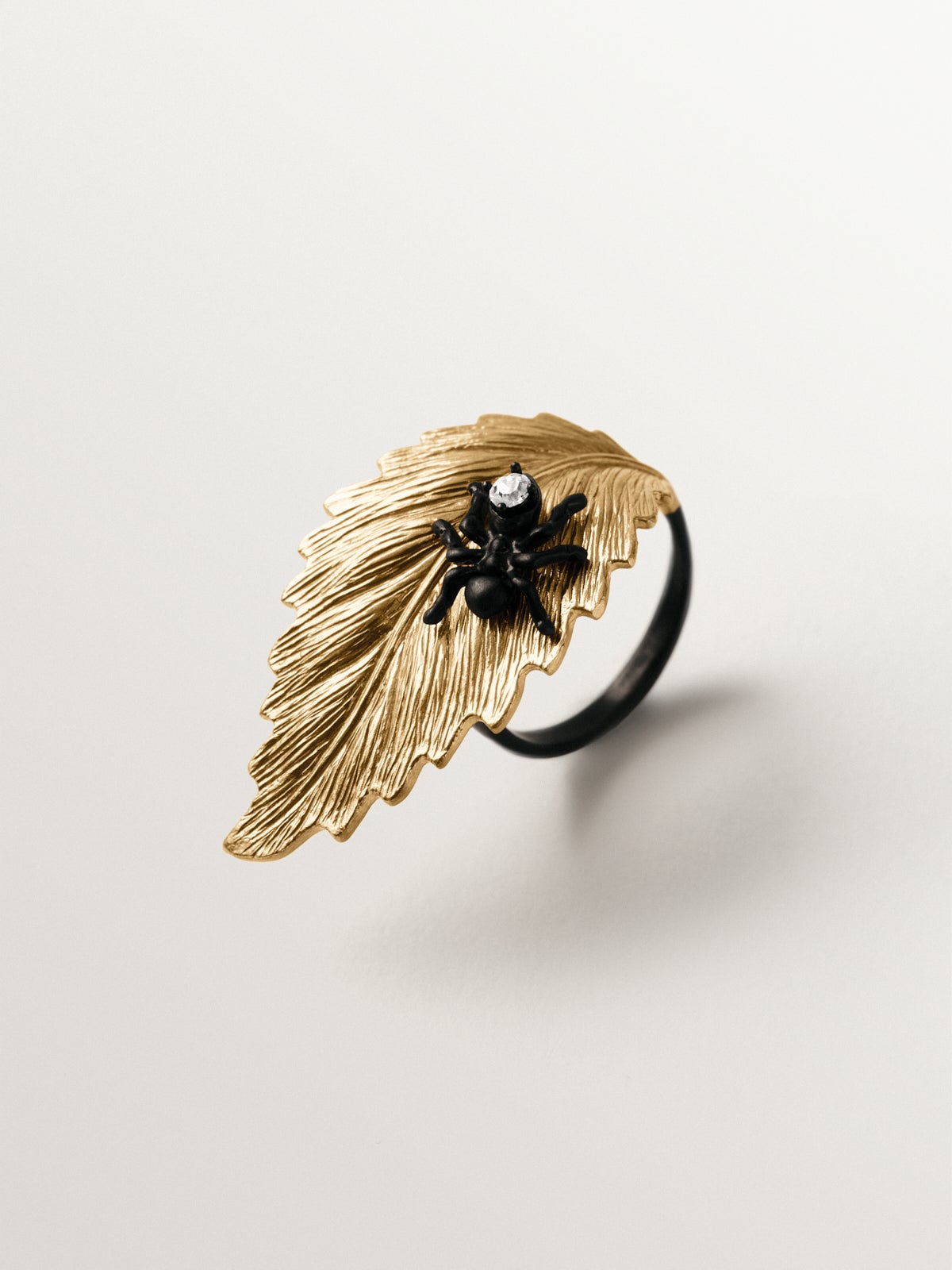 Anillo bañado en oro amarillo con cristales y forma de hoja