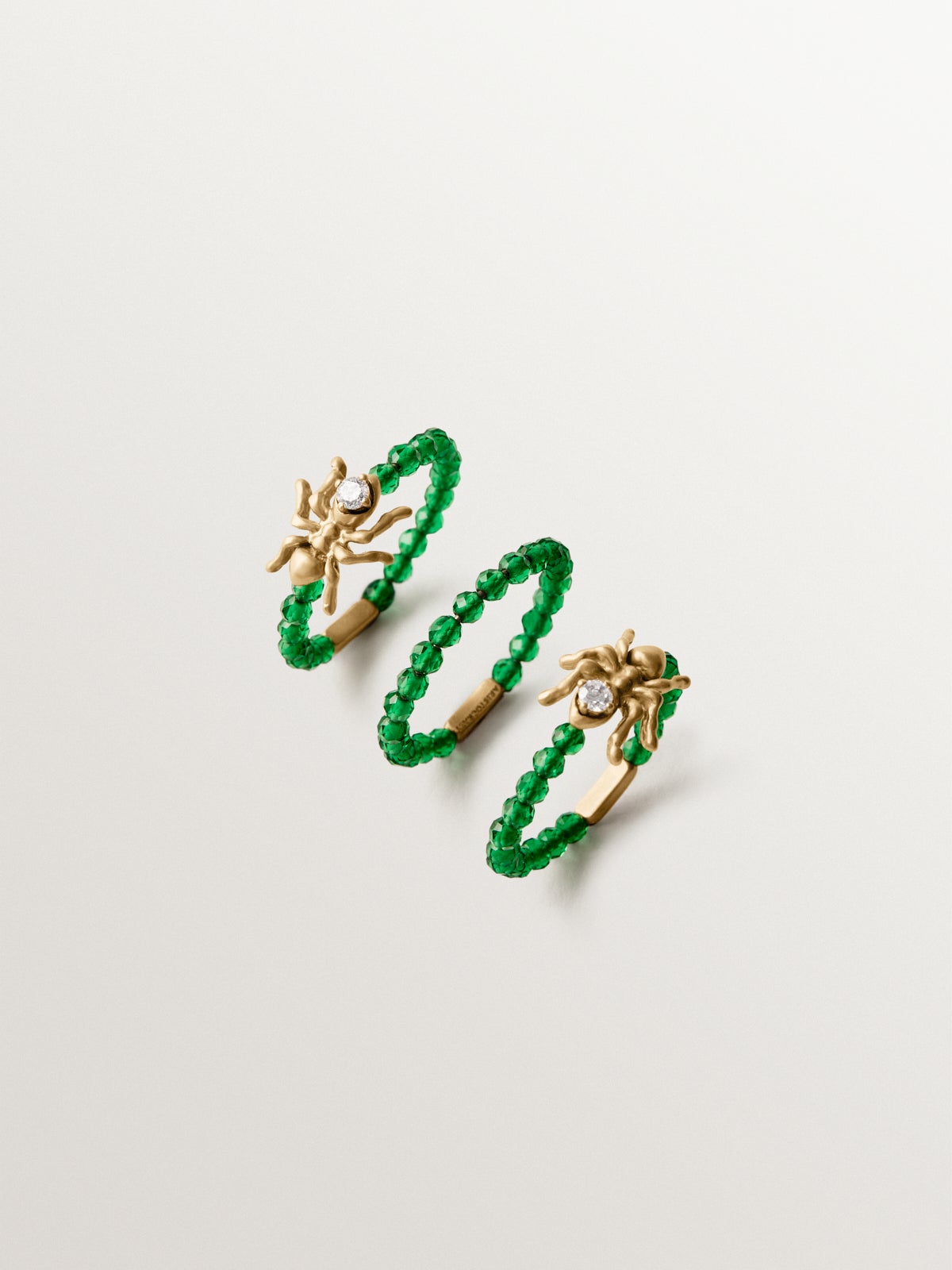 Anillo triple bañado en oro amarillo con cristales blancos y verdes y motivos de hormigas