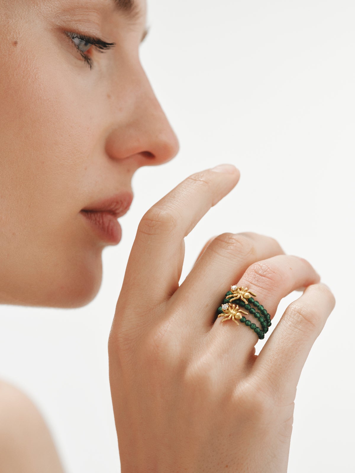 Anillo triple bañado en oro amarillo con cristales blancos y verdes y motivos de hormigas