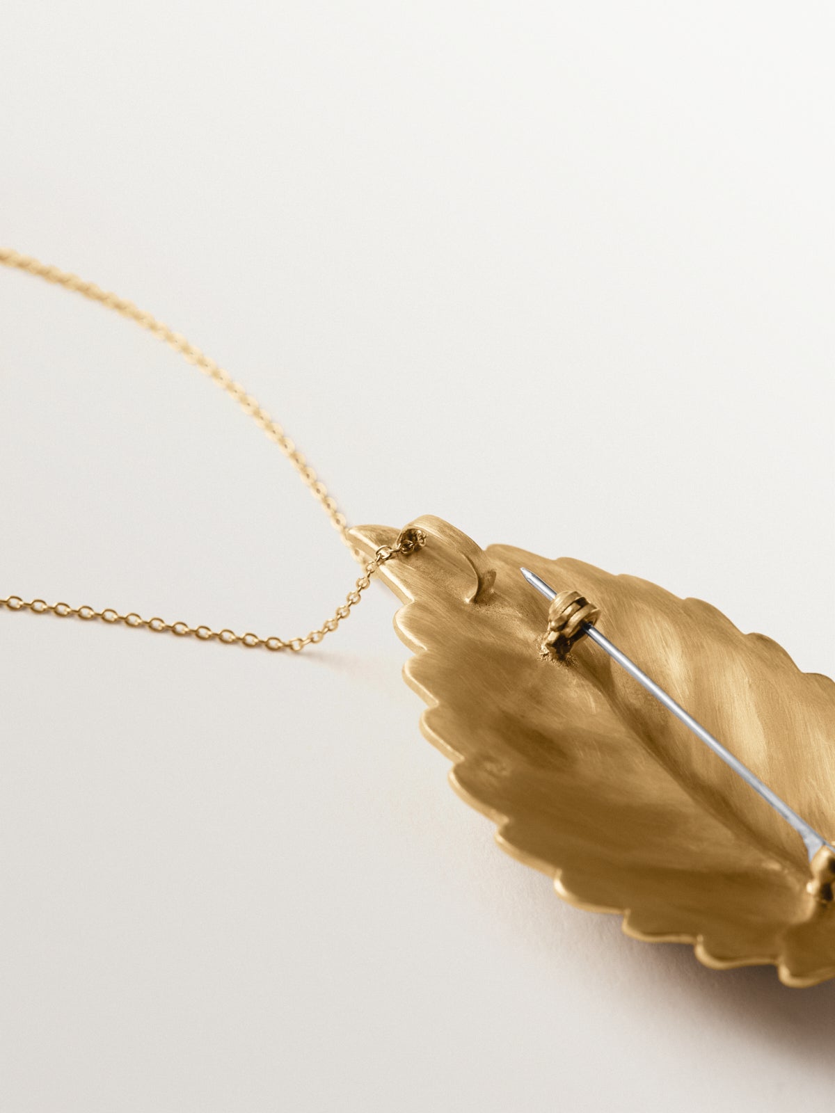 Broche-charm bañado en oro amarillo con cristales y forma de hoja e insectos