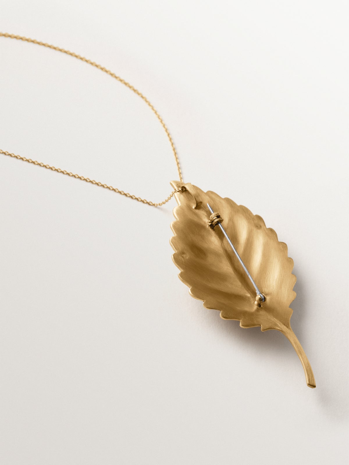 Broche-charm bañado en oro amarillo con cristales y forma de hoja e insectos