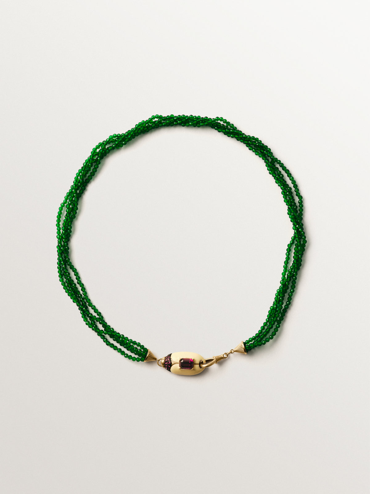 Collar bañado en oro amarillo con cuentas de cristales verdes y forma de escarabajo con cristales rojos