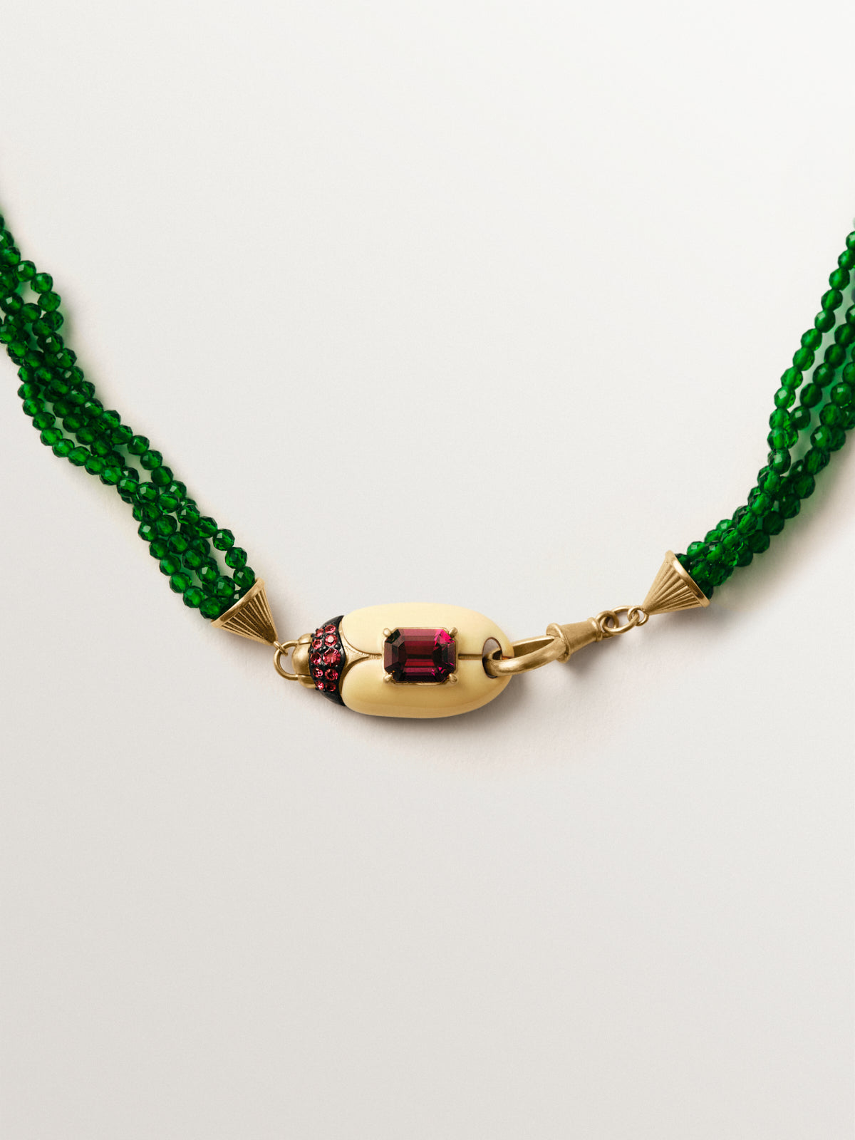Collar bañado en oro amarillo con cuentas de cristales verdes y forma de escarabajo con cristales rojos