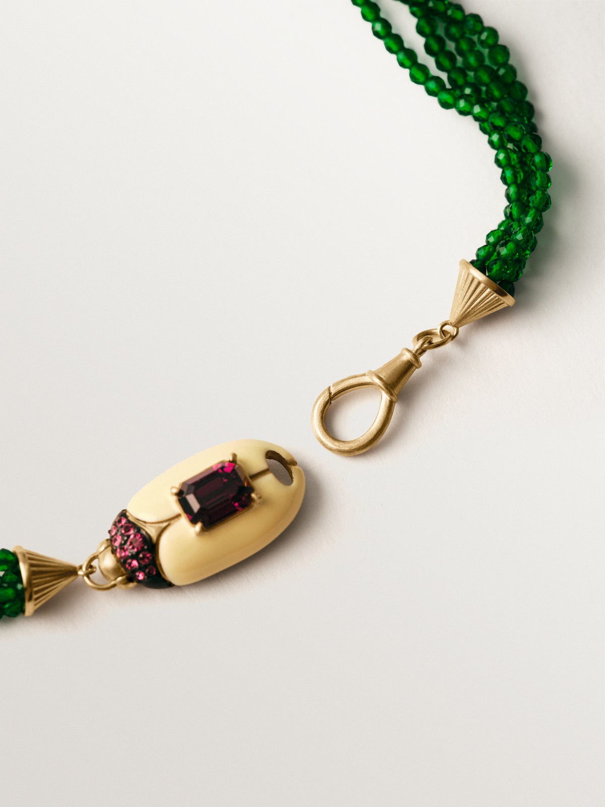 Yellow gold-plated necklace with green crystal beads and beetle shape with purple crystals