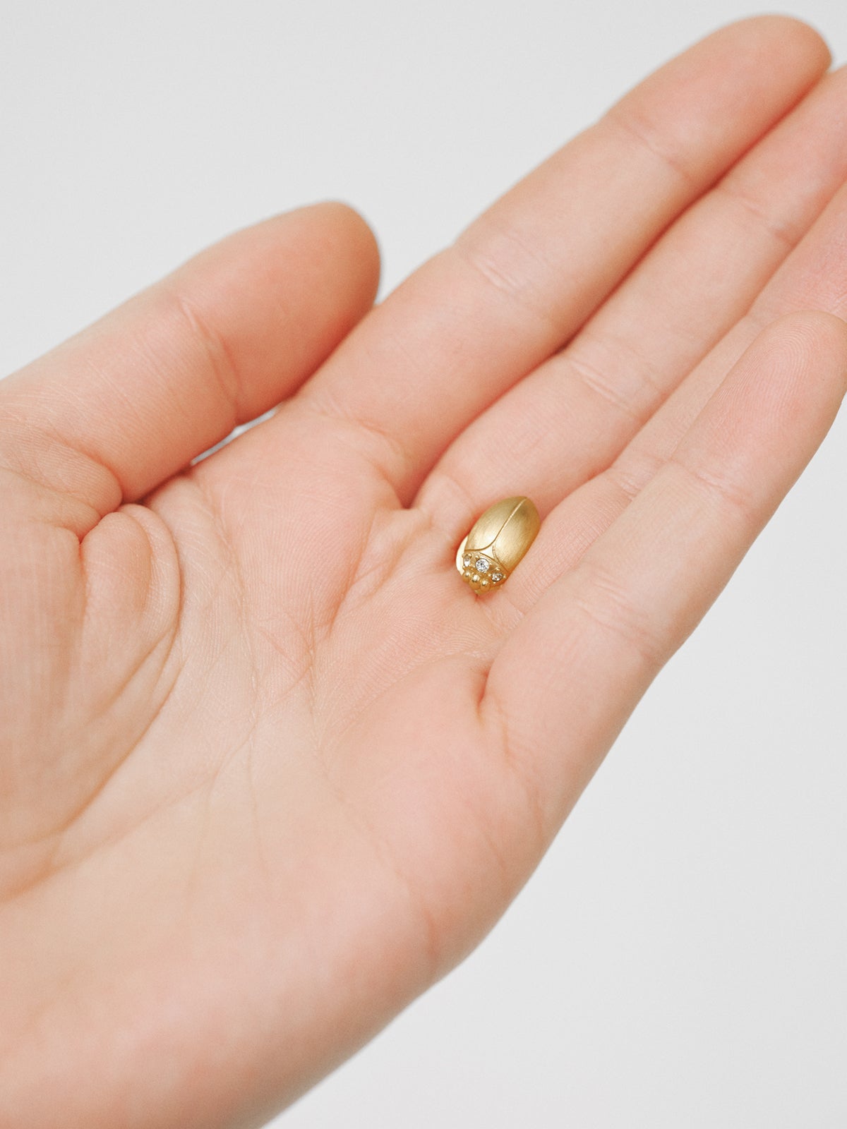 Pin bañado en oro amarillo con cristal y forma de escarabajo