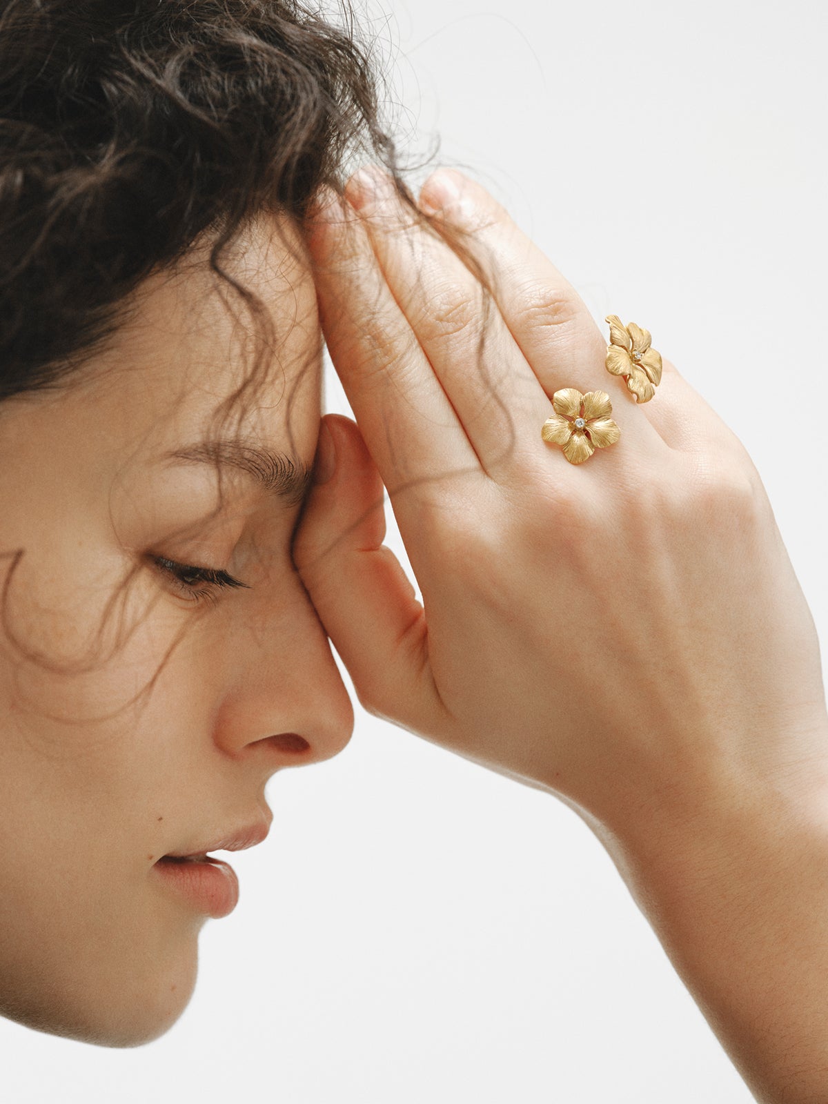 Anillo abierto bañado en oro amarillo con cristales y motivo de flor