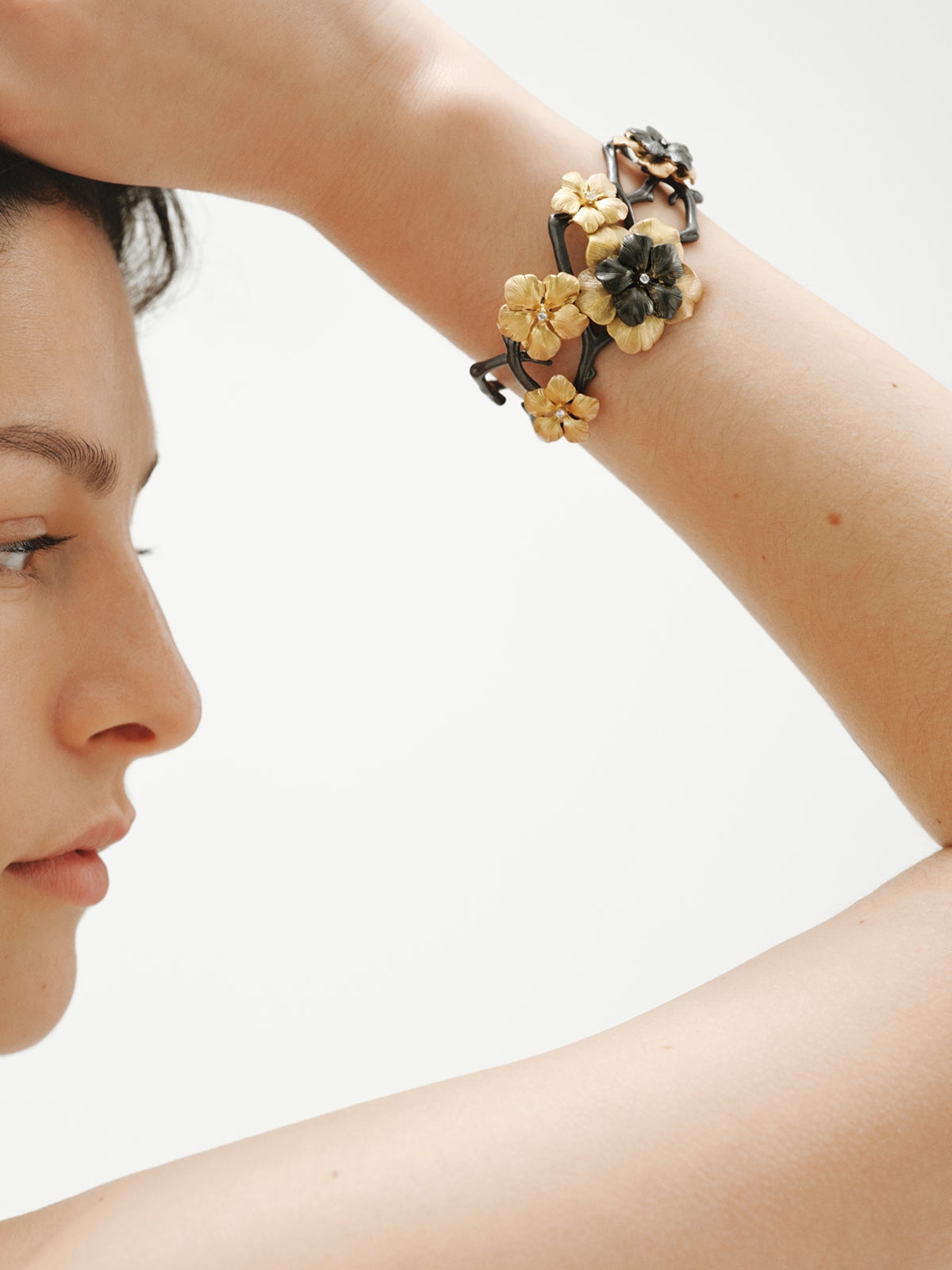 Pulsera rígida bicolor bañada en oro amarillo con cristales y motivo de flor