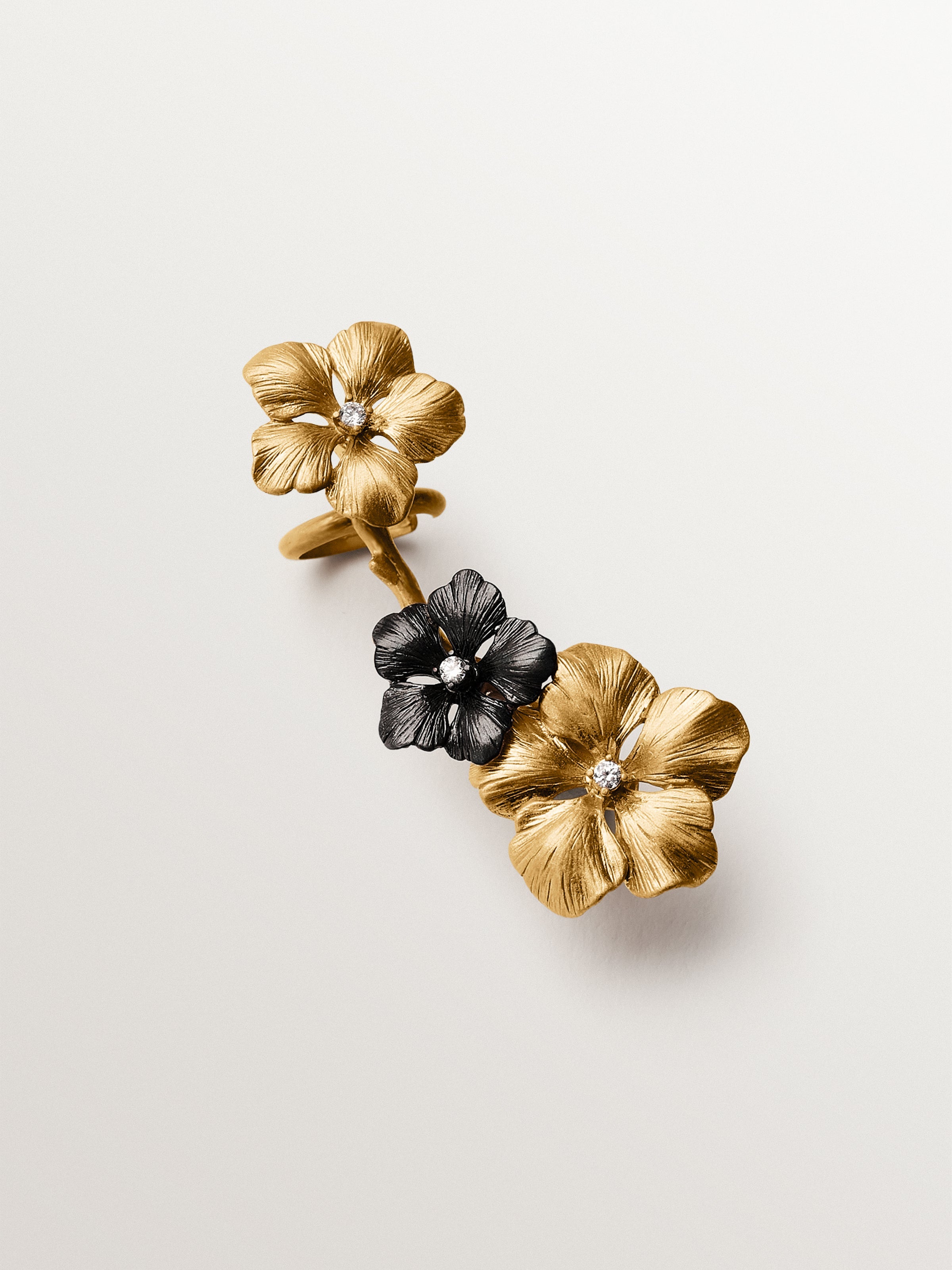 Earcuff trepador bañado en oro amarillo con cristales y motivos de flor