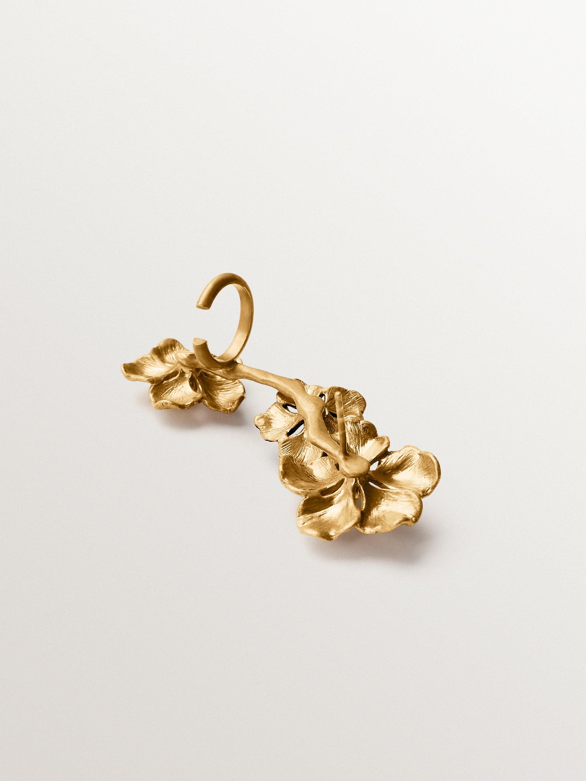 Earcuff trepador bañado en oro amarillo con cristales y motivos de flor