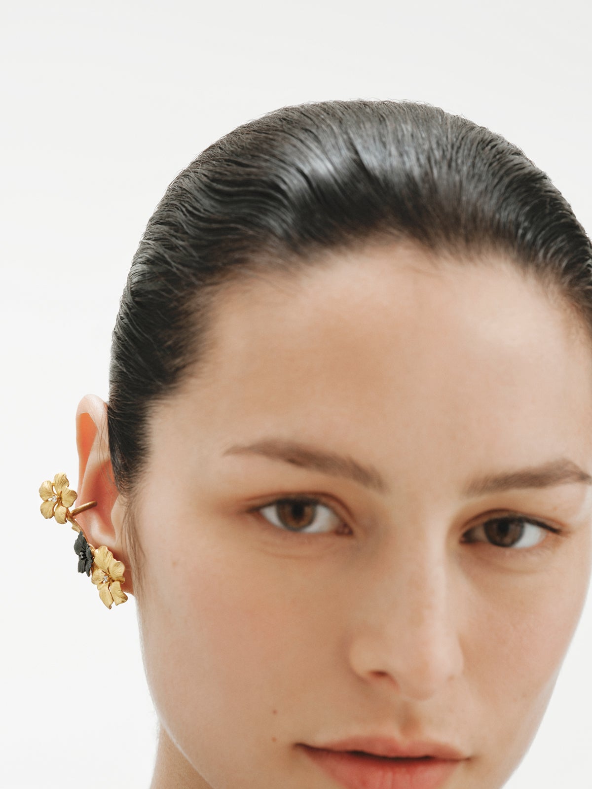 Earcuff trepador bañado en oro amarillo con cristales y motivos de flor