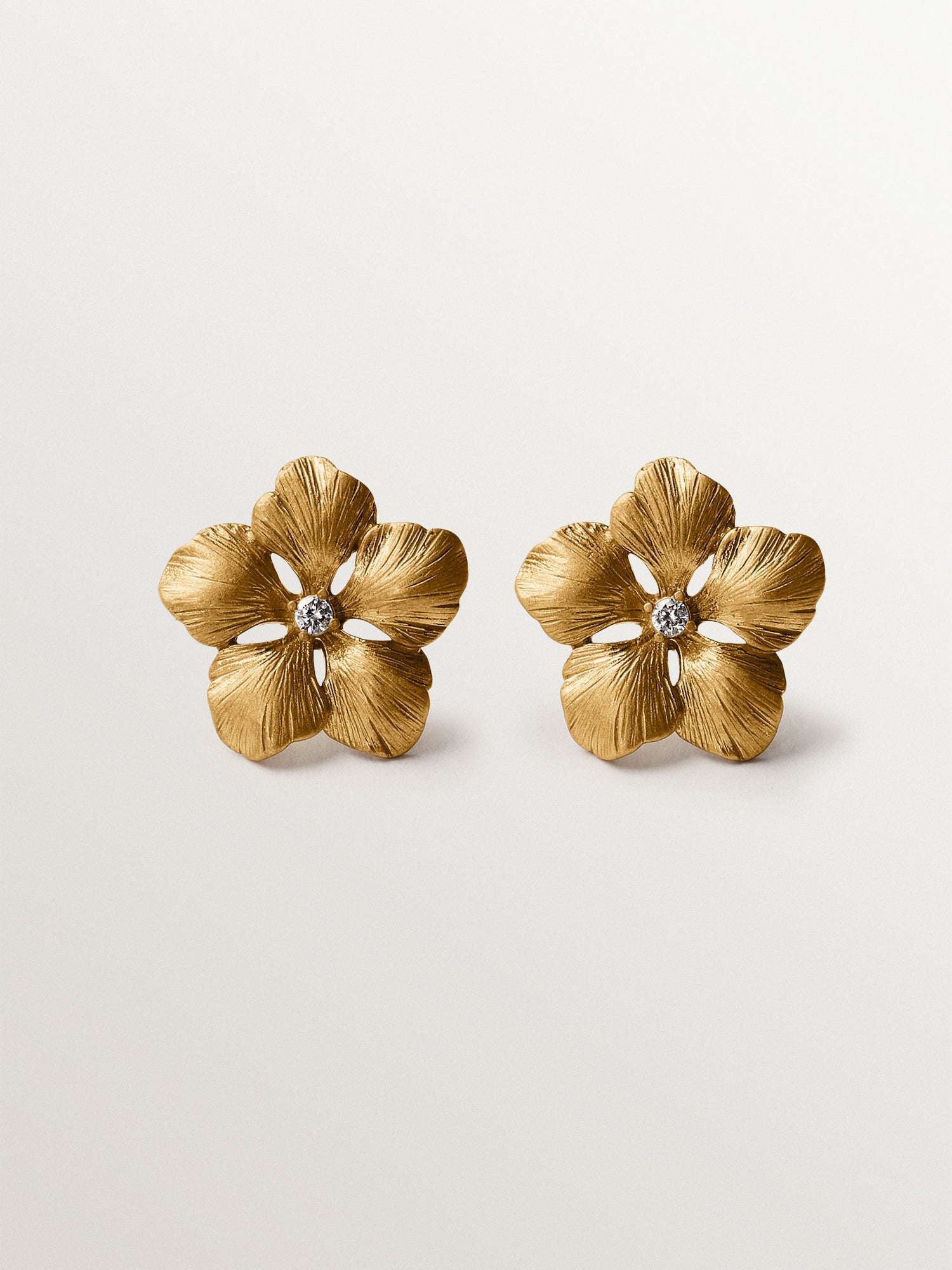 Pendientes de botón bañado en oro amarillo con cristal y forma de flor