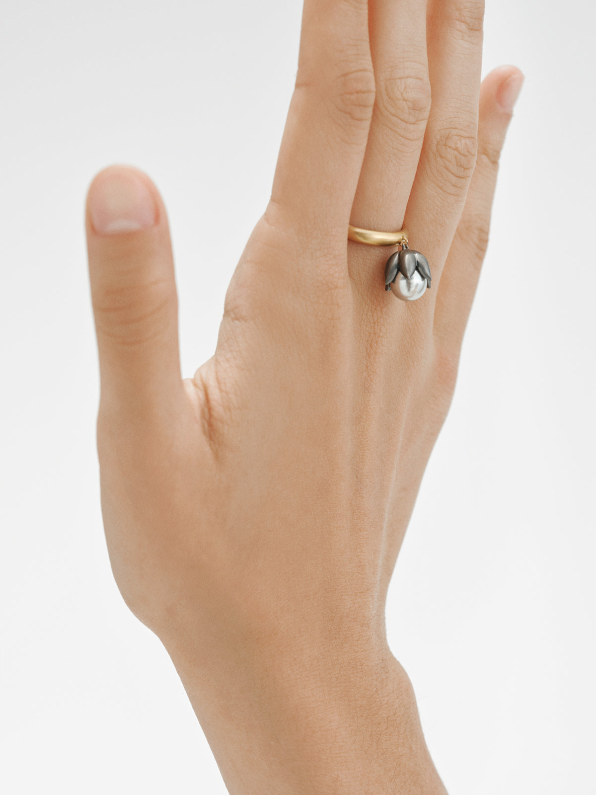 Anillo bicolor bañado en oro amarillo de 18K con acabado gunmetal, perla gris y motivo floral