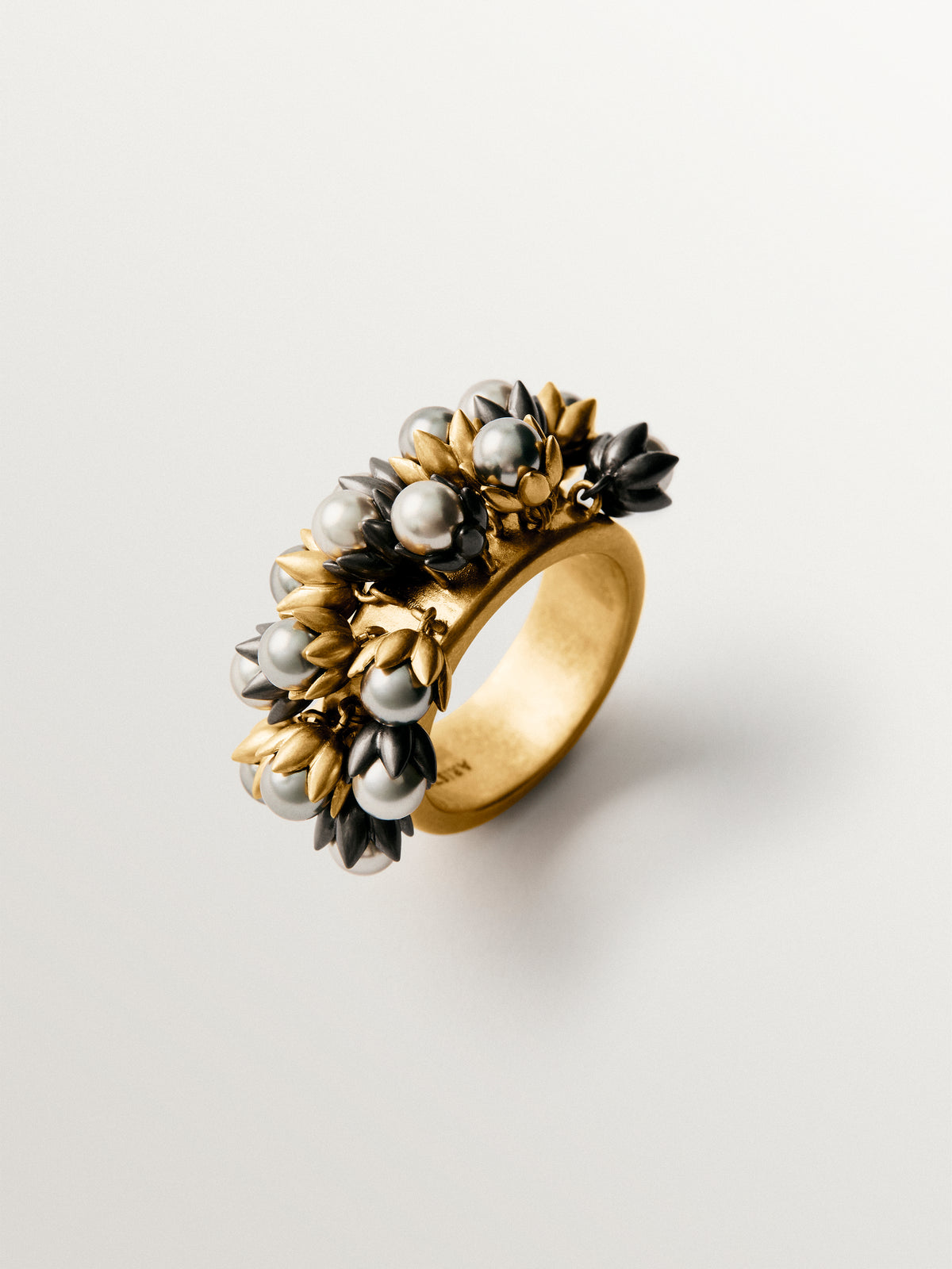 Anillo bañado en oro amarillo con acabado gunmetal y cristales grises con motivos florales