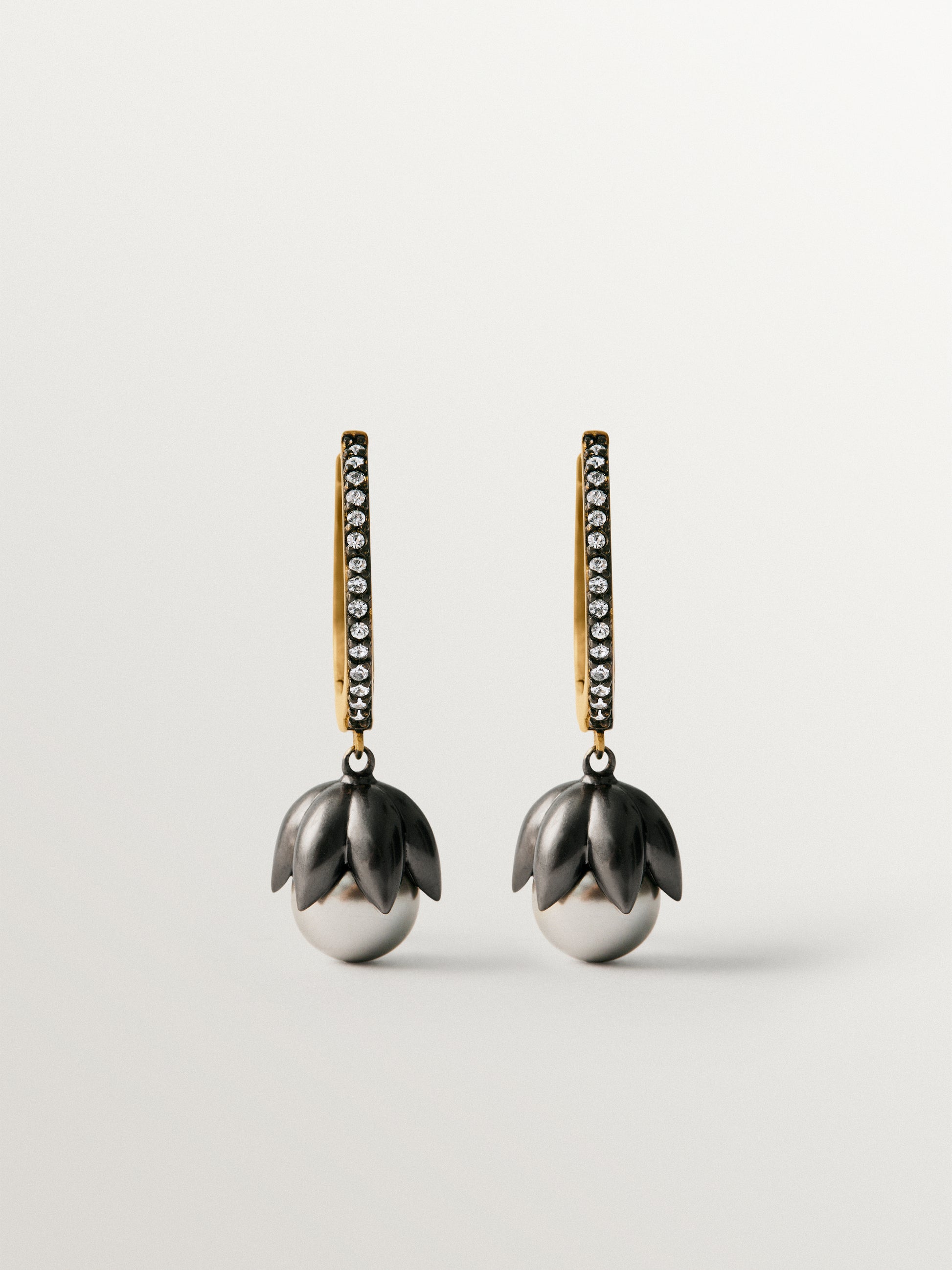 Pendientes bicolor de aro bañados en oro amarillo con acabado gunmetal, perlas grises, cristales y forma de flor