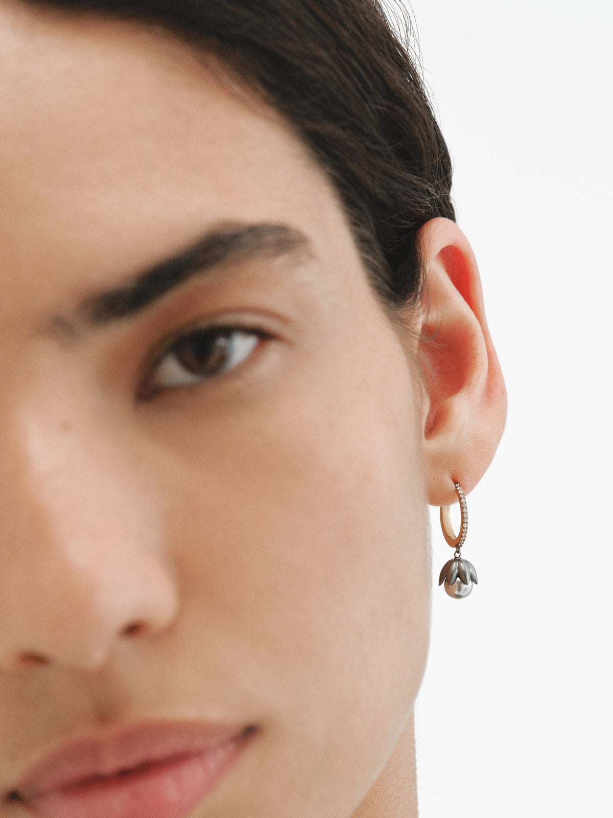 Pendientes bicolor de aro bañados en oro amarillo con acabado gunmetal, perlas grises, cristales y forma de flor