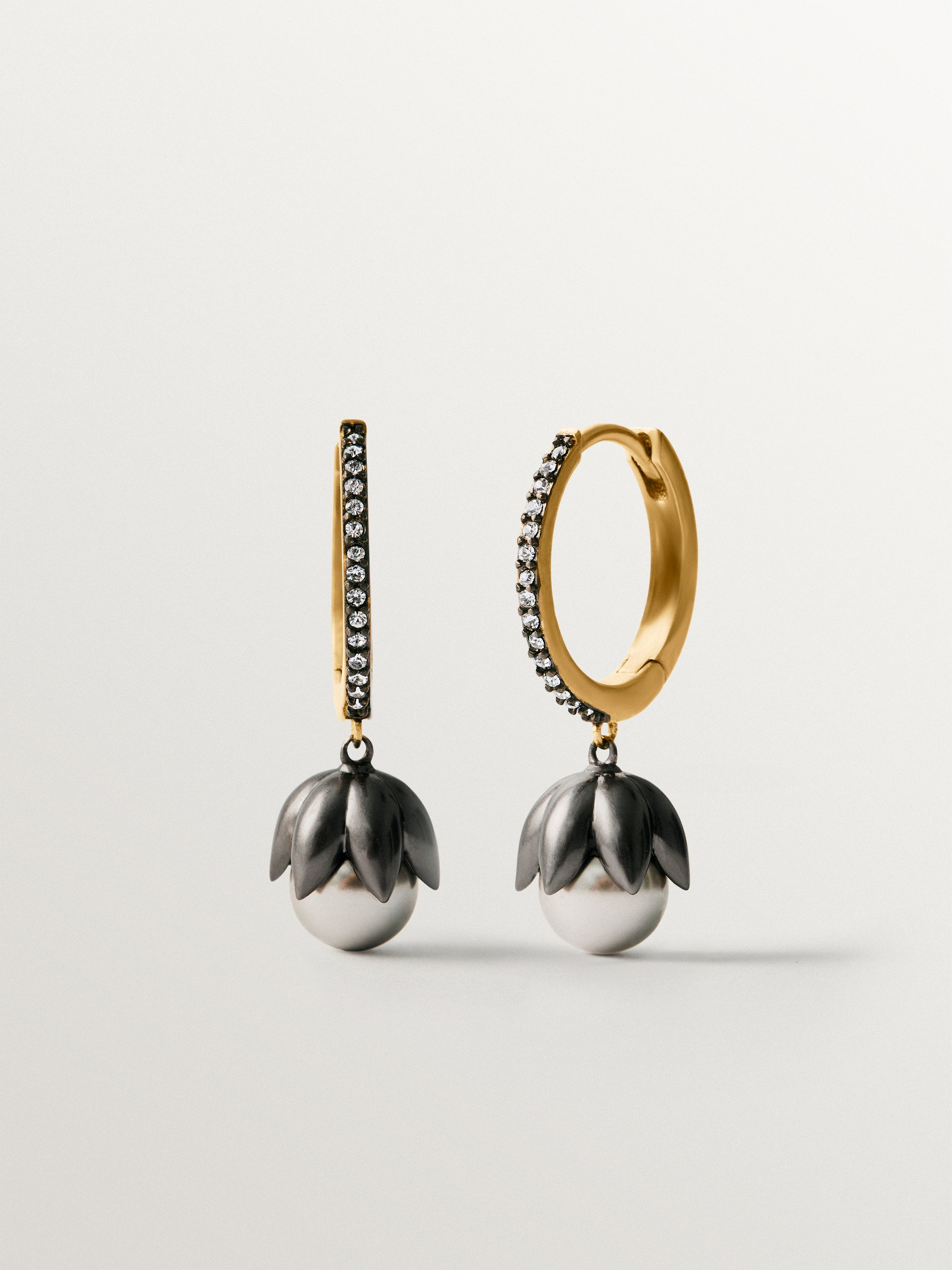 Pendientes bicolor de aro bañados en oro amarillo con acabado gunmetal, perlas grises, cristales y forma de flor
