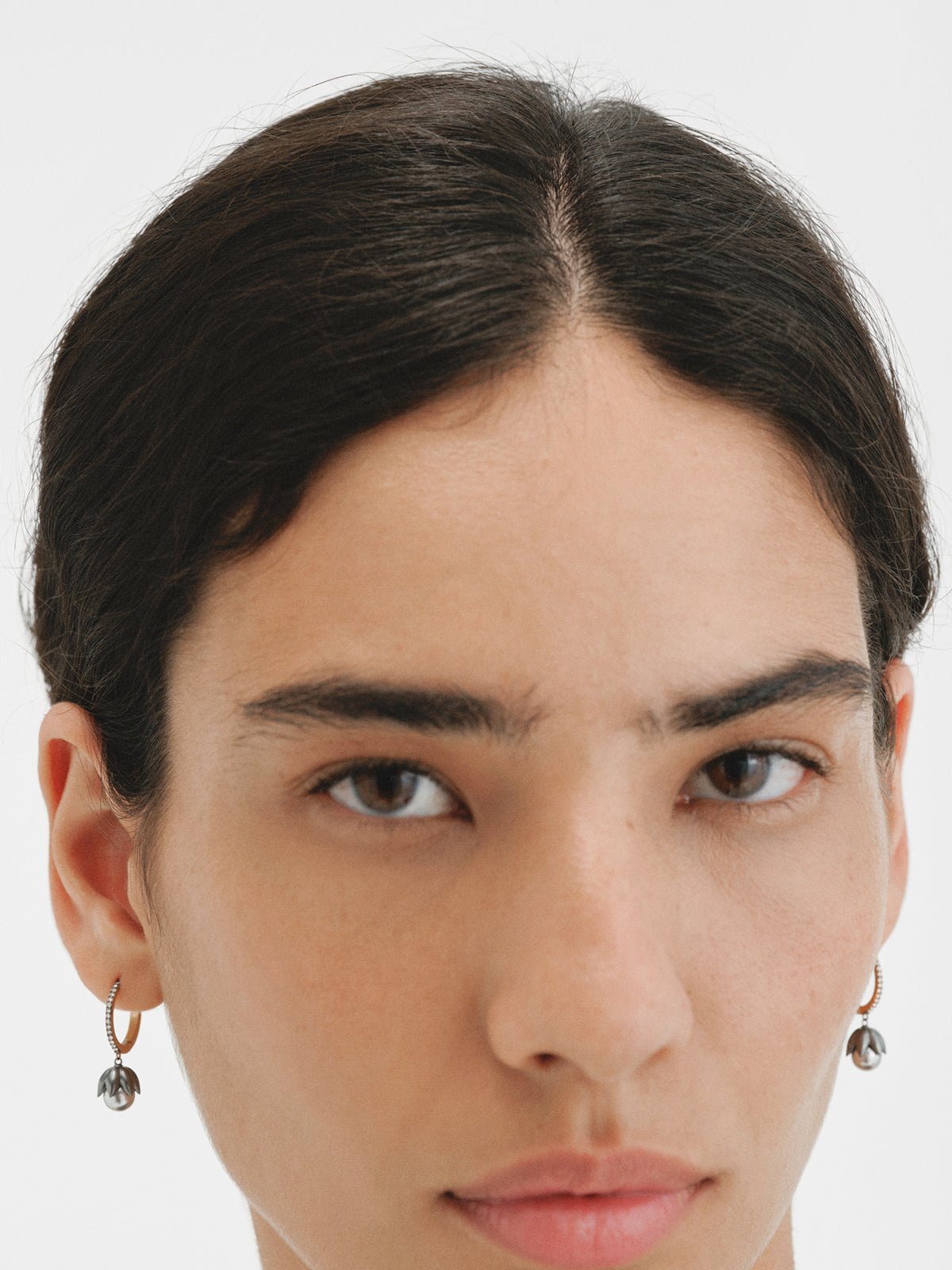 Pendientes bicolor de aro bañados en oro amarillo con acabado gunmetal, perlas grises, cristales y forma de flor