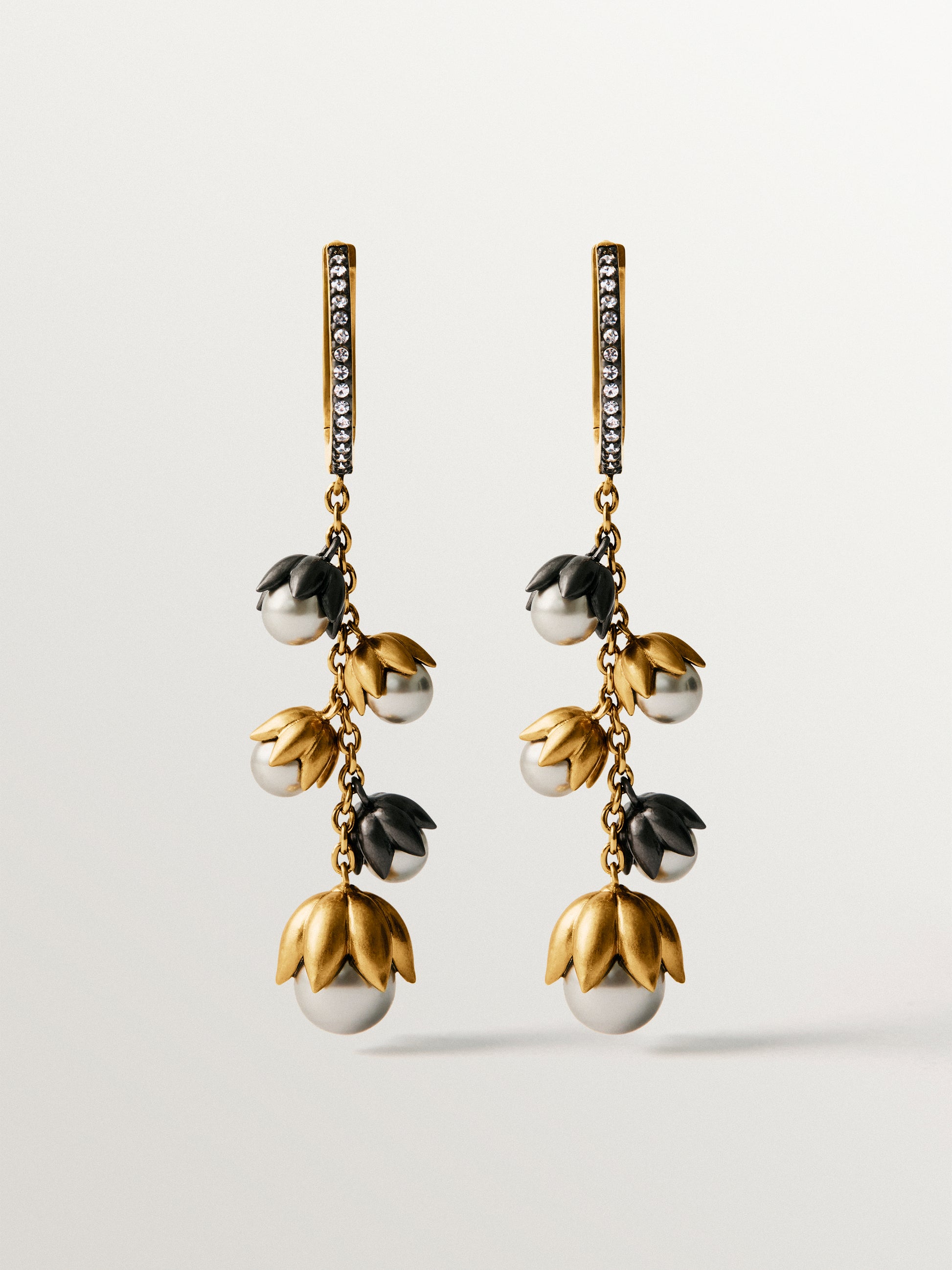 Pendientes bicolor bañados en oro amarillo con acabado gunmetal, perlas grises, cristales y forma de flor