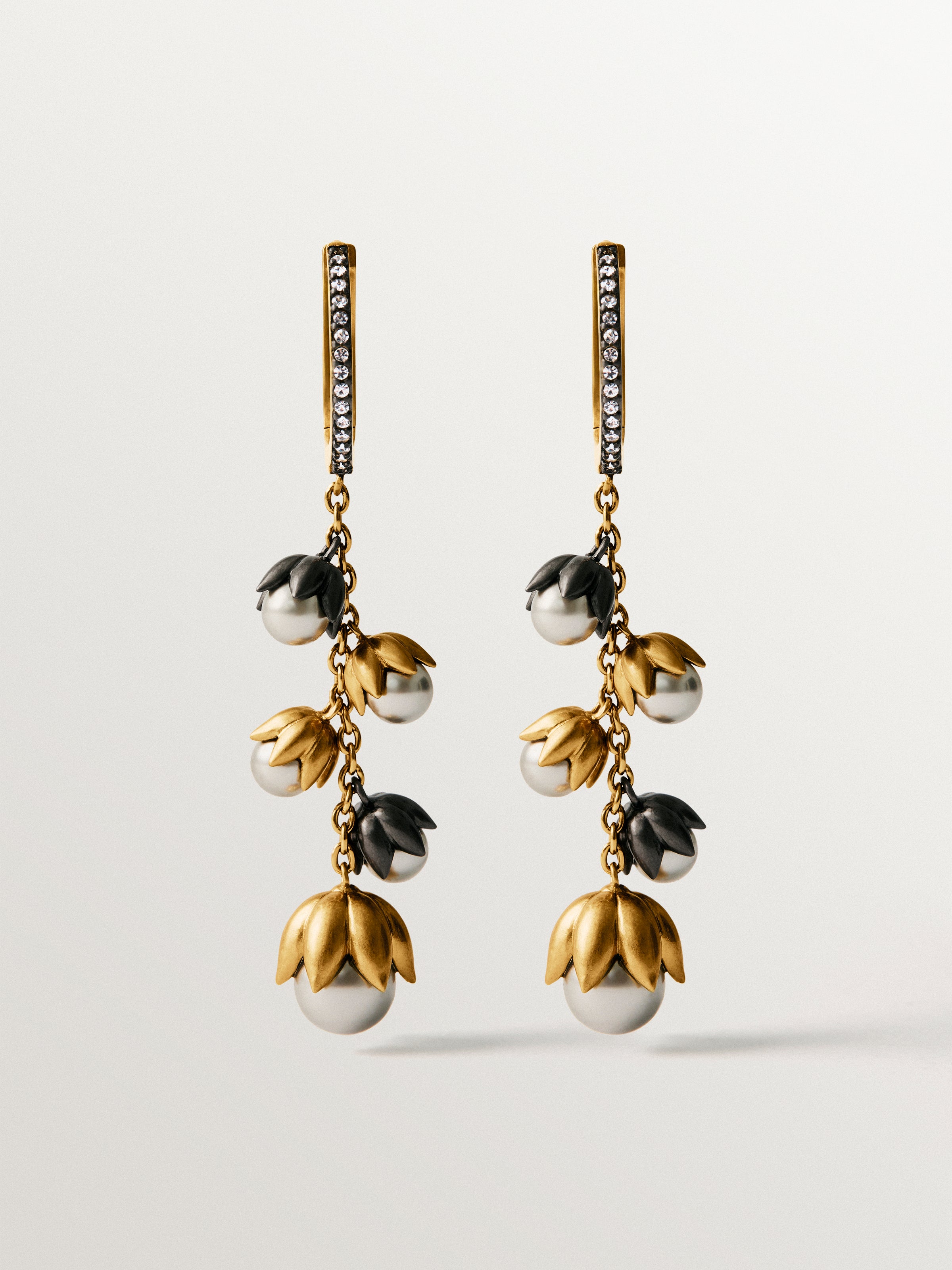 Pendientes bicolor bañados en oro amarillo con acabado gunmetal, perlas grises, cristales y forma de flor