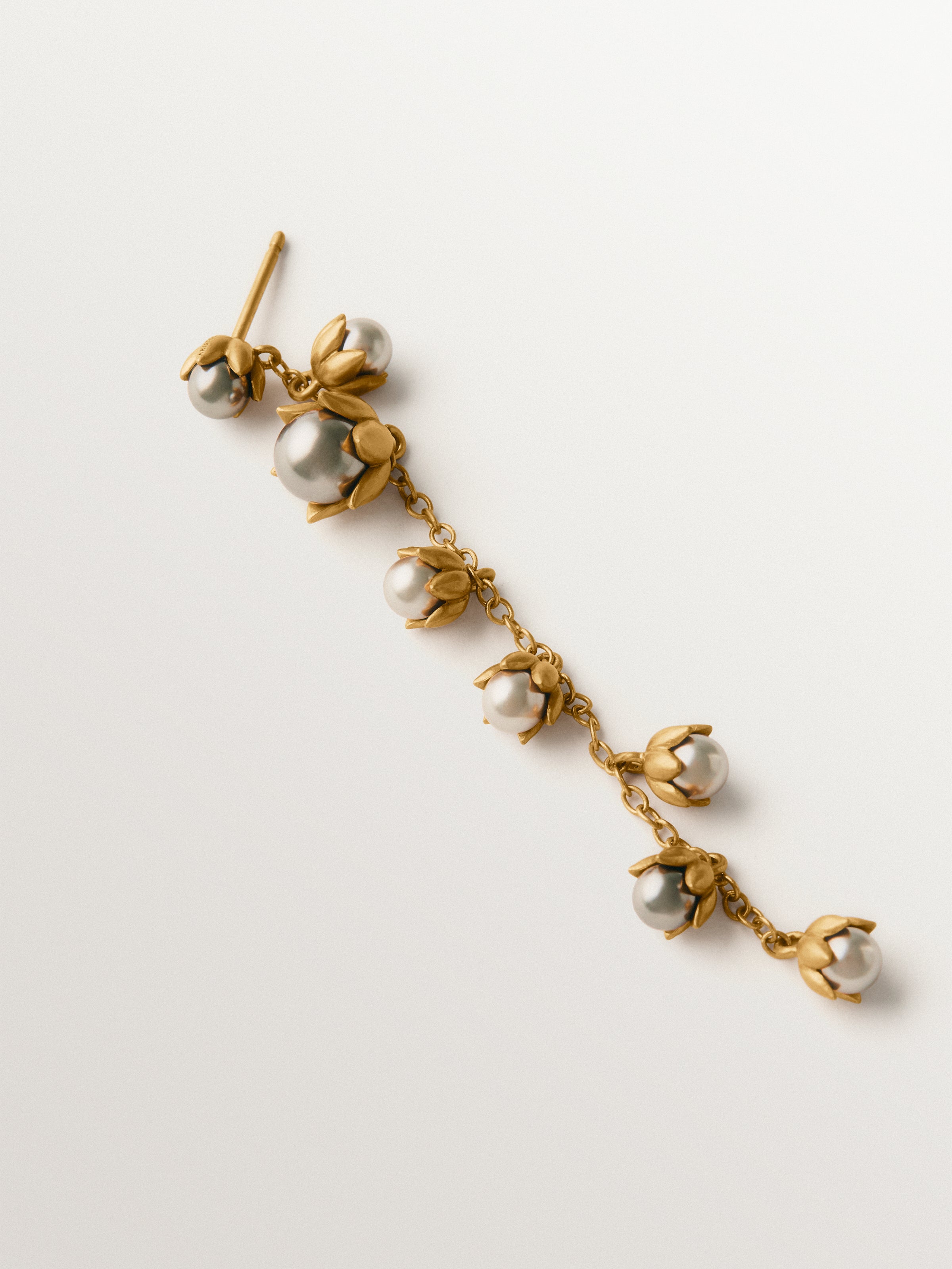 Pendiente individual bicolor bañado en oro amarillo con acabado gunmetal, perlas grises y motivos florales