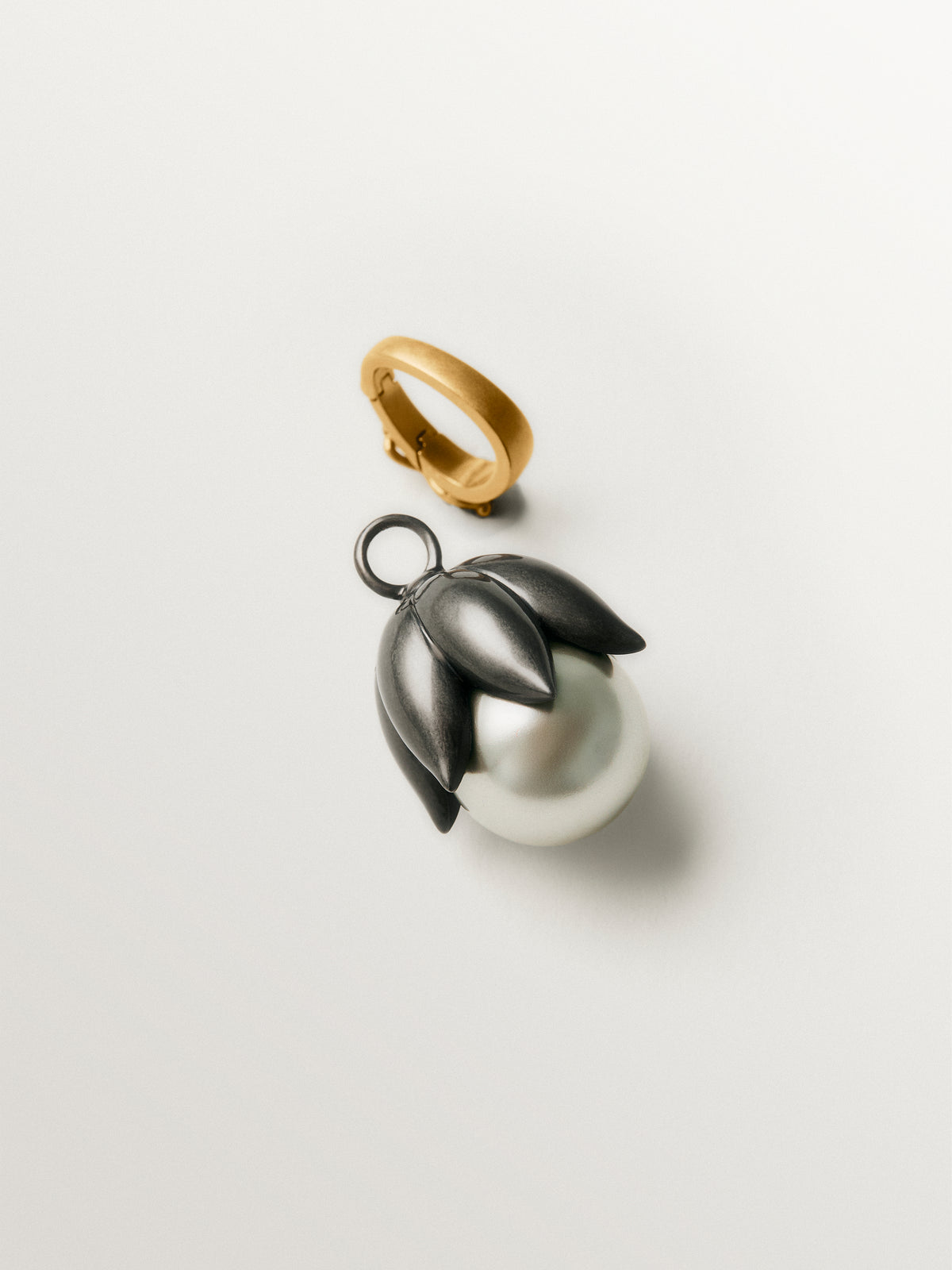Charm bicolor bañado en oro amarillo con acabado gumetal y cristal gris en forma de flor