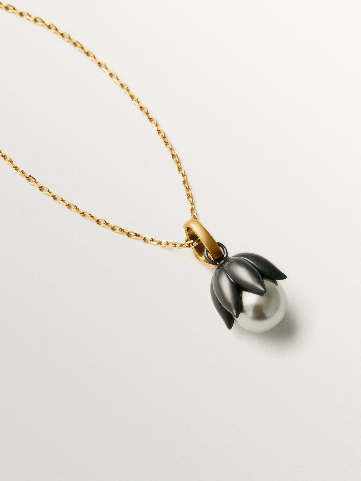 Charm bicolor bañado en oro amarillo con acabado gumetal y cristal gris en forma de flor