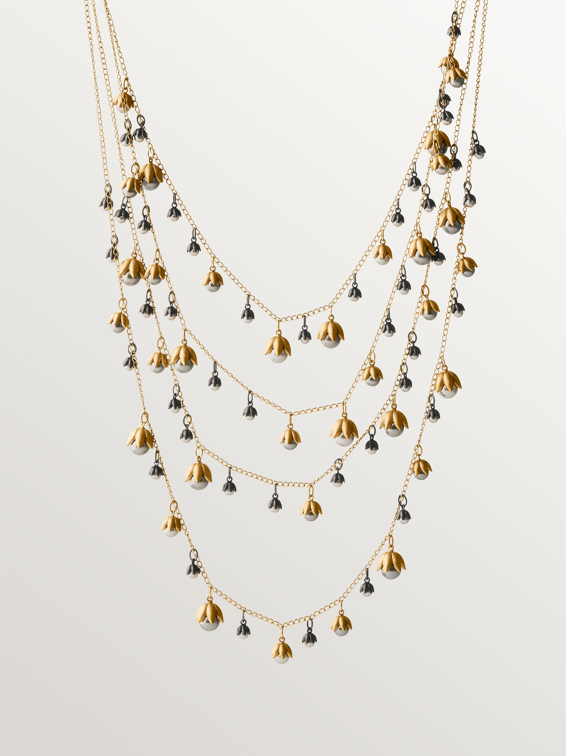 Collar bicolor bañado en oro amarillo y acabado gunmetal con perlas grises y motivos florales 